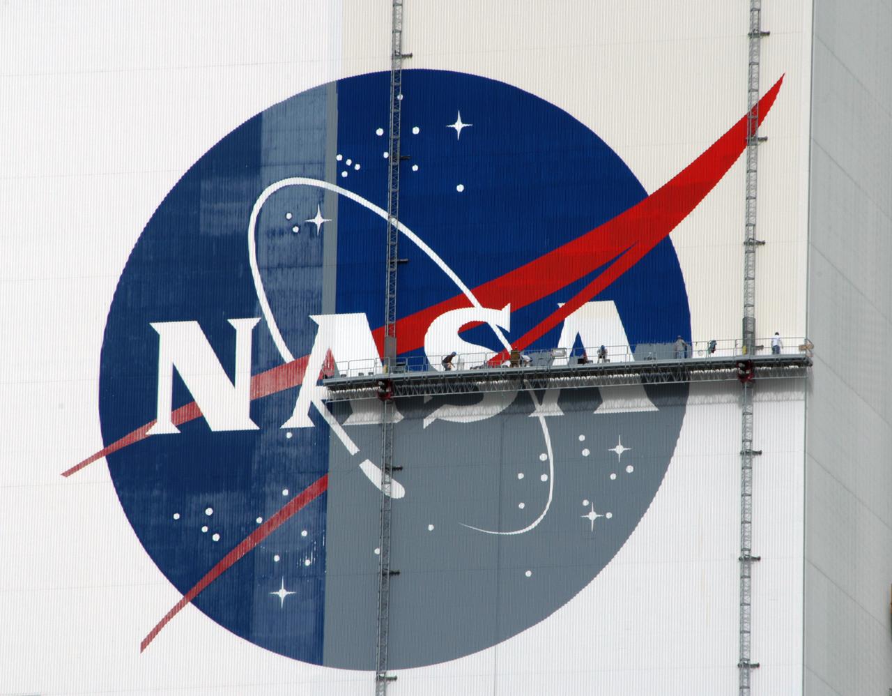 Workers painting the Flag and Meatball on the VAB.