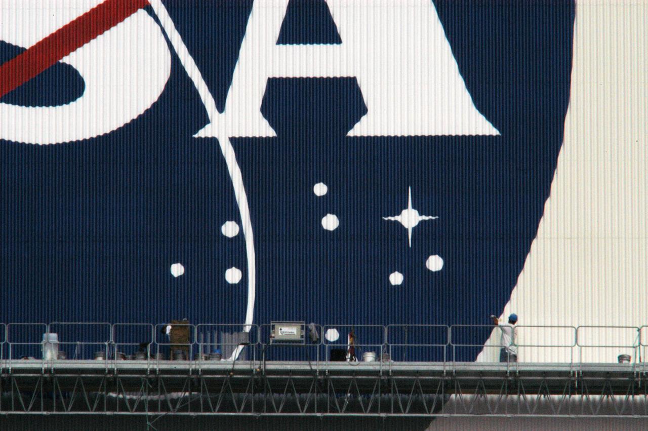 Workers painting the Flag and Meatball on the VAB.