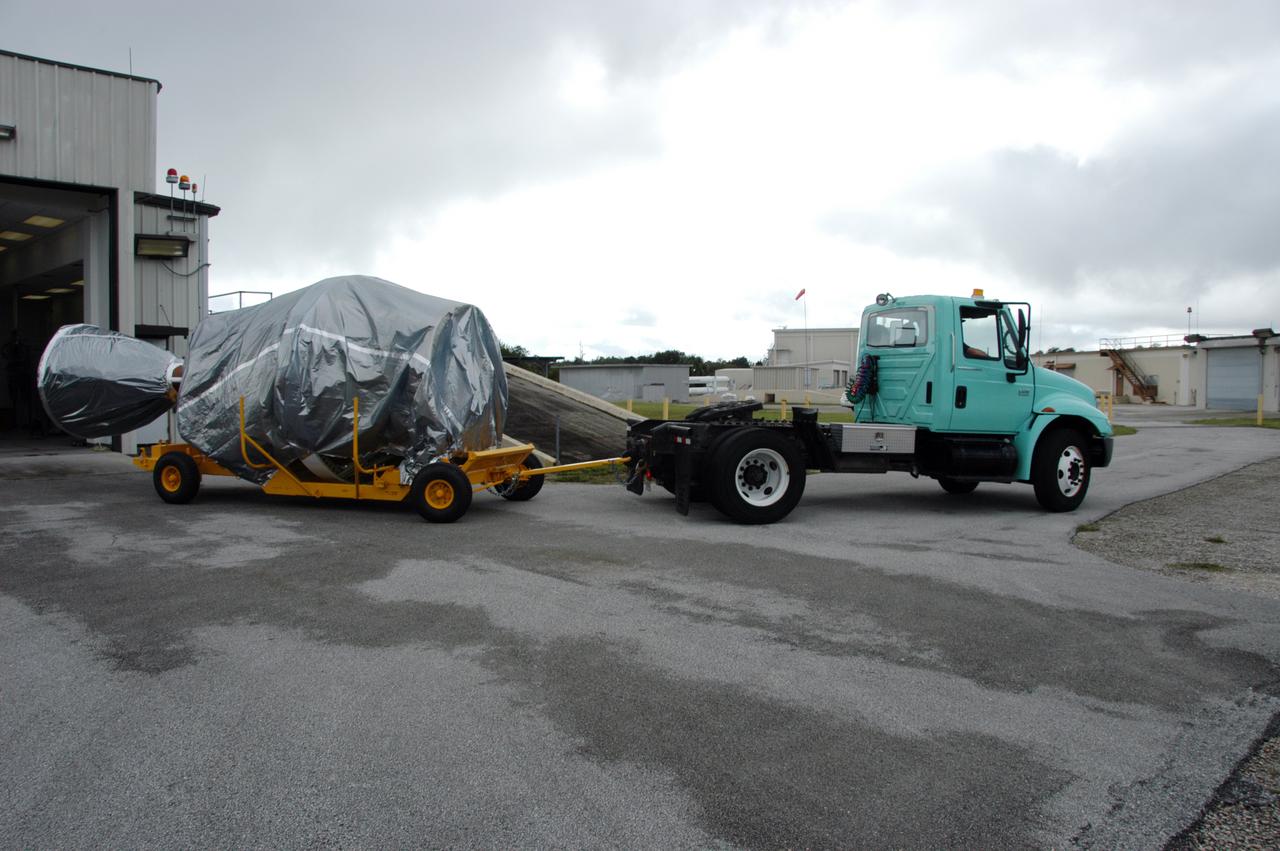 The covered Delta II second stage arrives at a checkout hangar on Cape Canaveral Air Force Station in Florida in preparation for transfer to Pad 17-B. At the pad, it will be lifted into the mobile service tower and mated with the first stage already in place. The Delta II is the launch vehicle for the THEMIS spacecraft. THEMIS consists of five identical probes, the largest number of scientific satellites ever launched into orbit aboard a single rocket. This unique constellation of satellites will resolve the tantalizing mystery of what causes the spectacular sudden brightening of the aurora borealis and aurora australis - the fiery skies over the Earth's northern and southern polar regions. THEMIS is scheduled to launch Feb. 15 from Cape Canaveral Air Force Station.