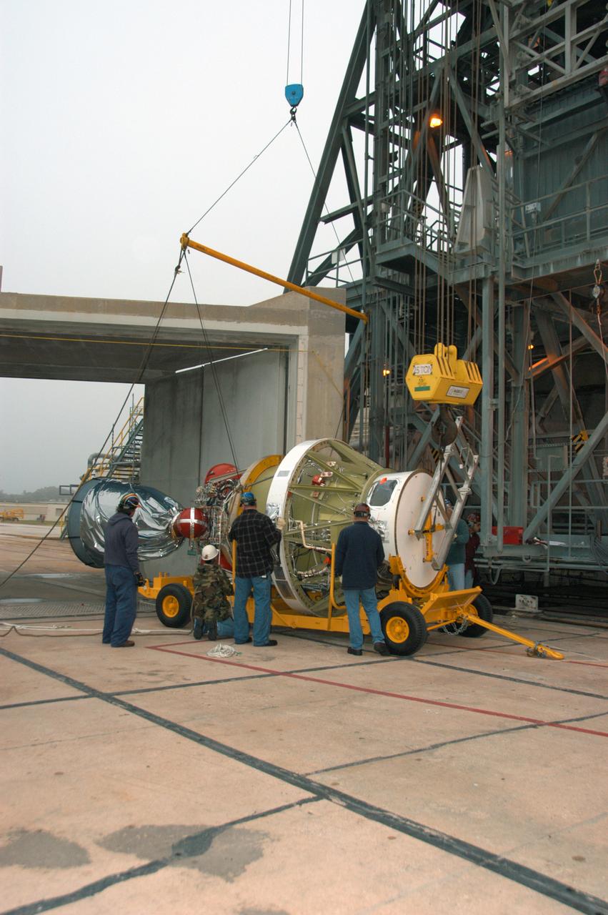 On Pad 17-B at Cape Canaveral Air Force Station, workers attach an overhead crane to the Delta II second stage in order to raise it to vertical. It will be lifted into the mobile service tower and mated with the first stage already in place. The Delta II is the launch vehicle for the THEMIS spacecraft. THEMIS consists of five identical probes, the largest number of scientific satellites ever launched into orbit aboard a single rocket. This unique constellation of satellites will resolve the tantalizing mystery of what causes the spectacular sudden brightening of the aurora borealis and aurora australis - the fiery skies over the Earth's northern and southern polar regions. THEMIS is scheduled to launch Feb. 15 from Cape Canaveral Air Force Station.