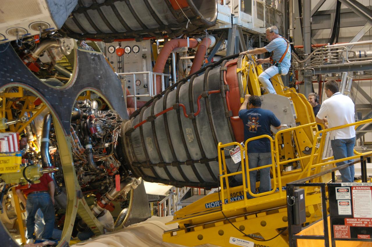 In Orbiter Processing Facility bay 2, technicians on a Hyster forklift maneuver space shuttle main engine no. 3 into place on Endeavour. Each space shuttle main engine is 14 feet long, weighs about 6,700 pounds, and is 7.5 feet in diameter at the end of the nozzle. The orbiter is scheduled for mission STS-118, targeted for launch on June 28. The mission will be the 22nd flight to the International Space Station, carrying another starboard array, S5, for installation.