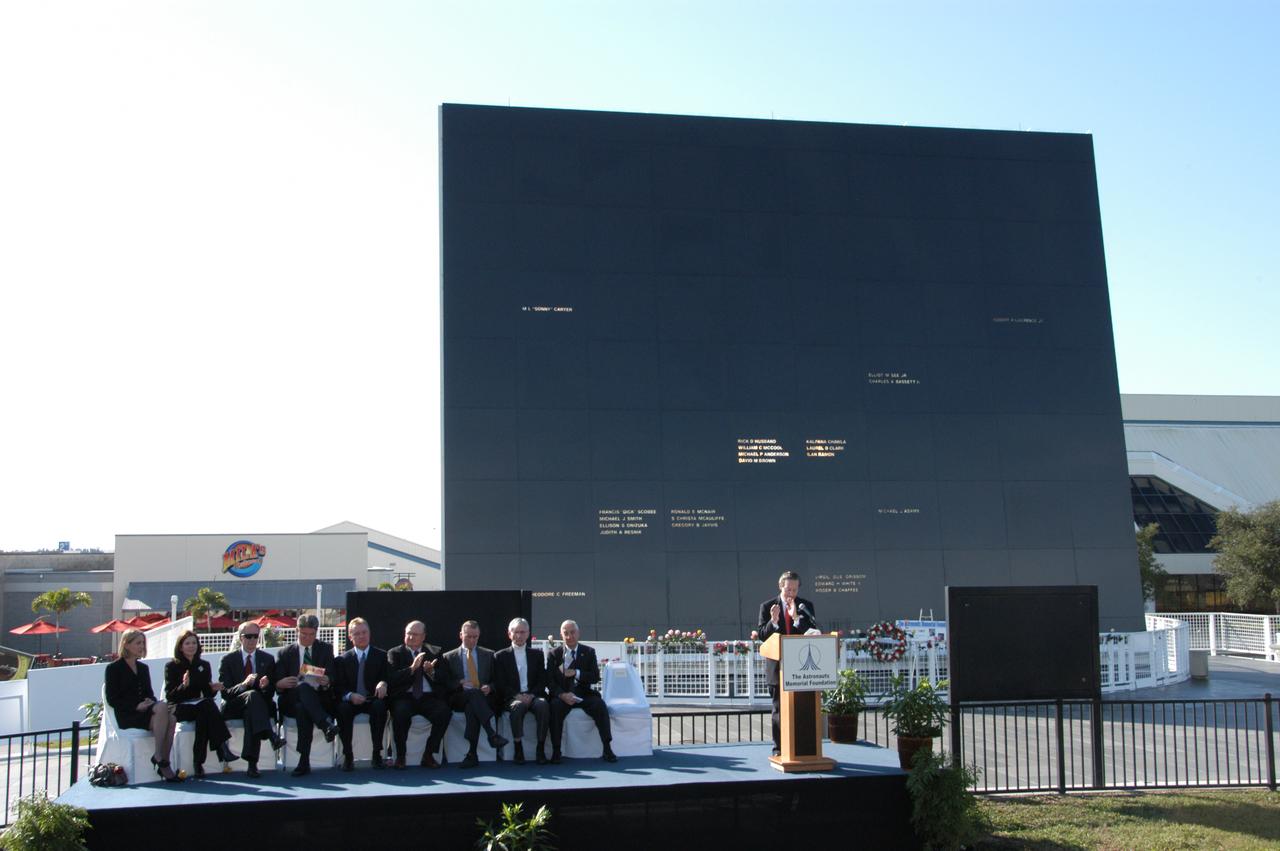 Guests are gathered on stage during a ceremony at the KSC Visitor Complex held in remembrance of the astronauts lost in the Apollo 1 fire: Virgil "Gus" Grissom, Edward H. White II and Roger B. Chaffee. Among those gathered on stage are (from left) Faith Johnson, daughter of Theodore Freeman and Martha Chaffee, daughter of Roger Chaffee, Associate Administrator for Space Operations William Gerstenmaier and KSC Director Bill Parsons, plus former astronaut John Young (second from right). Members of the astronauts' families were guests at the ceremony. At the podium is Stephen Feldman, president of the Astronauts Memorial Foundation. Behind the stage is the Space Mirror Memorial, designated as a national memorial by Congress and President George Bush in 1991 to honor fallen astronauts. Their names are emblazoned on the monument’s 42-1/2-foot-high by 50-foot-wide black granite surface as if to be projected into the heavens. 