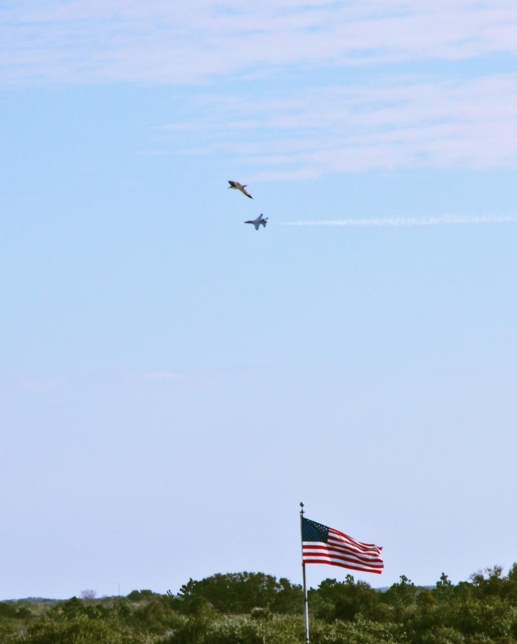 Look -- It's a bird and a plane! A U.S. Air Force Thunderbird F-16D aircraft streaks through the sky past a slower-flying stork over the NASA News Center. The pilot is Maj. Tad Clark, who, after landing at the Shuttle Landing Facility, announced that Kennedy Space Center Visitor Complex will host the inaugural World Space Expo from Nov. 3 to 11, featuring an aerial salute by the Thunderbirds on its opening weekend. The Expo will create one of the largest displays of space artifacts, hardware and personalities ever assembled in one location with the objective to inspire, educate and engage the public by highlighting the achievements and benefits of space exploration. 