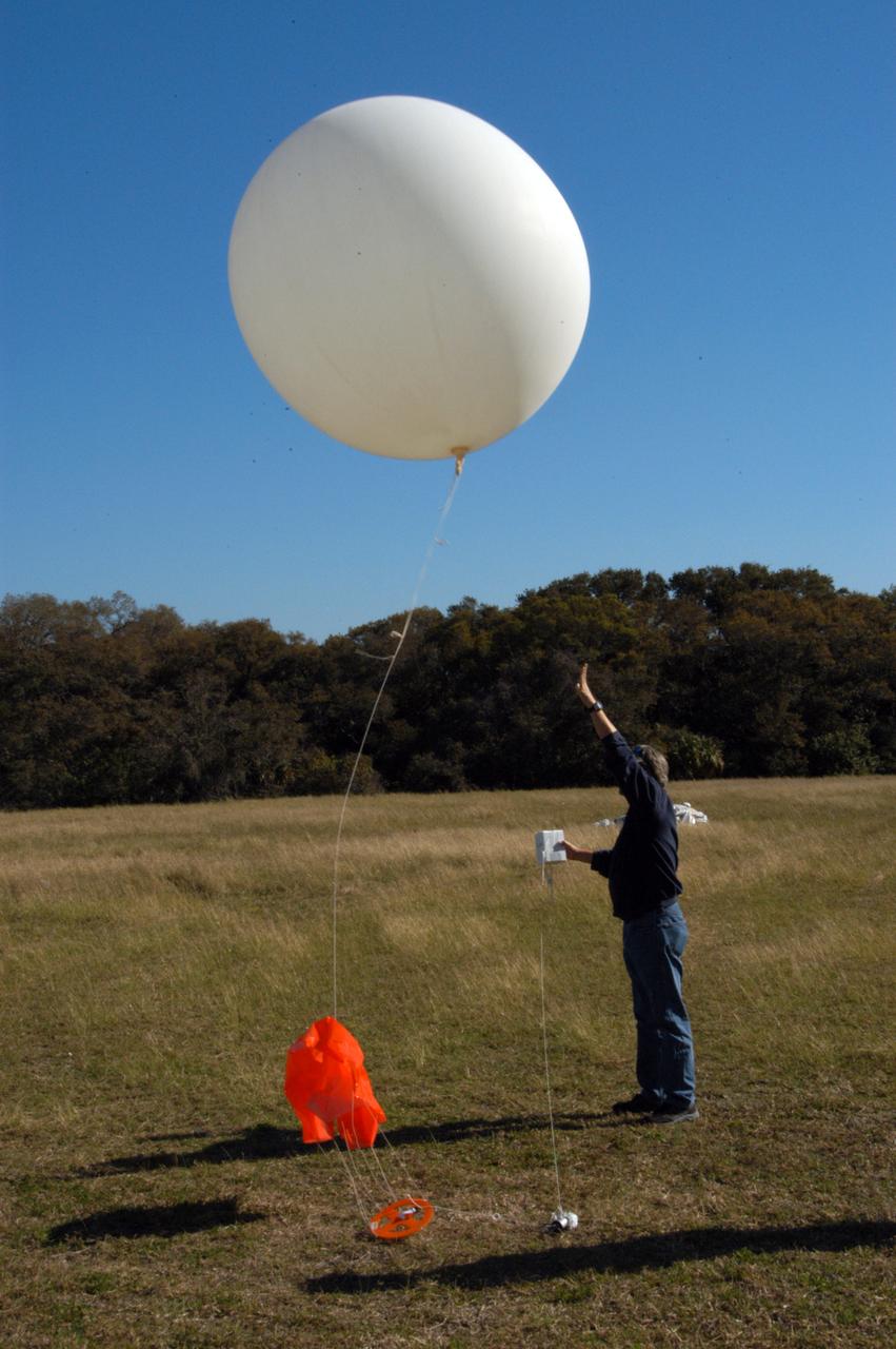 A worker releases a weather balloon at the Cape Canaveral Air Force Station weather station. The balloon is equipped with a radiosonde, an instrument that transmits measurements on atmospheric pressure, humidity, temperature and winds as it ascends. The data will be used to determine if conditions are acceptable for the launch of NASA's THEMIS mission. THEMIS, an acronym for Time History of Events and Macroscale Interactions during Substorms, consists of five identical probes that will track violent, colorful eruptions near the North Pole. This will be the largest number of scientific satellites NASA has ever launched into orbit aboard a single rocket. The THEMIS mission aims to unravel the mystery behind auroral substorms, an avalanche of magnetic energy powered by the solar wind that intensifies the northern and southern lights. The mission will investigate what causes auroras in the Earth’s atmosphere to dramatically change from slowly shimmering waves of light to wildly shifting streaks of bright color. Launch is planned from Pad 17-B in a window that extends from 6:01 to 6:19 p.m. EST. 