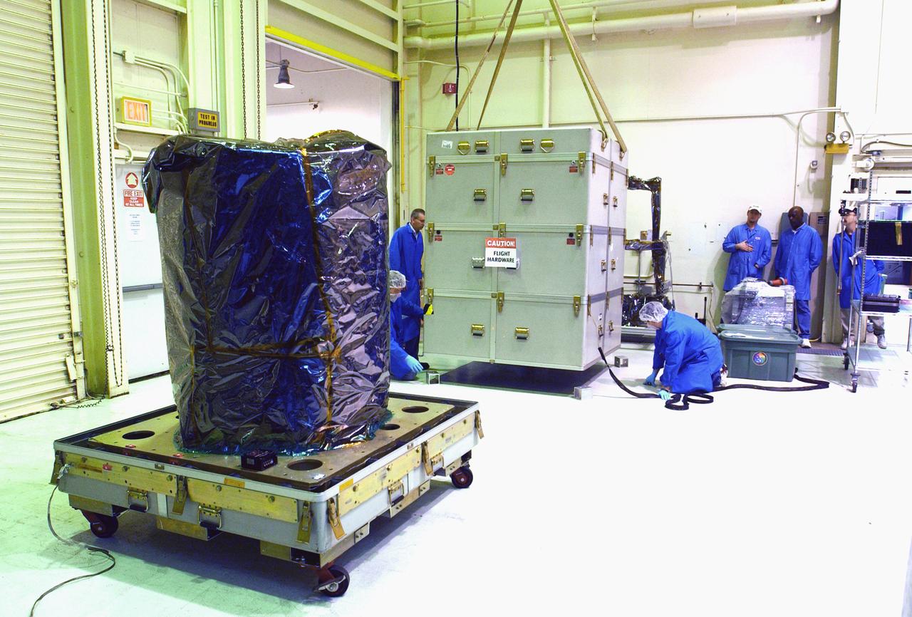 Inside a clean room at Vandenberg Air Force Base in California, the shipping container removed from around NASA's Aeronomy of Ice in the Mesosphere, or AIM, spacecraft at left, is lowered onto the floor nearby. AIM is the seventh Small Explorers mission under NASA's Explorer Program. The program provides frequent flight opportunities for world-class scientific investigations from space within heliophysics and astrophysics. The AIM spacecraft will fly three instruments designed to study polar mesospheric clouds located at the edge of space, 50 miles above the Earth's surface in the coldest part of the planet's atmosphere. The mission's primary goal is to explain why these clouds form and what has caused them to become brighter and more numerous and appear at lower latitudes in recent years. AIM's results will provide the basis for the study of long-term variability in the mesospheric climate and its relationship to global climate change. AIM is scheduled to be mated to the Pegasus XL during the second week of April, after which final inspections will be conducted. Launch is scheduled for April 25.