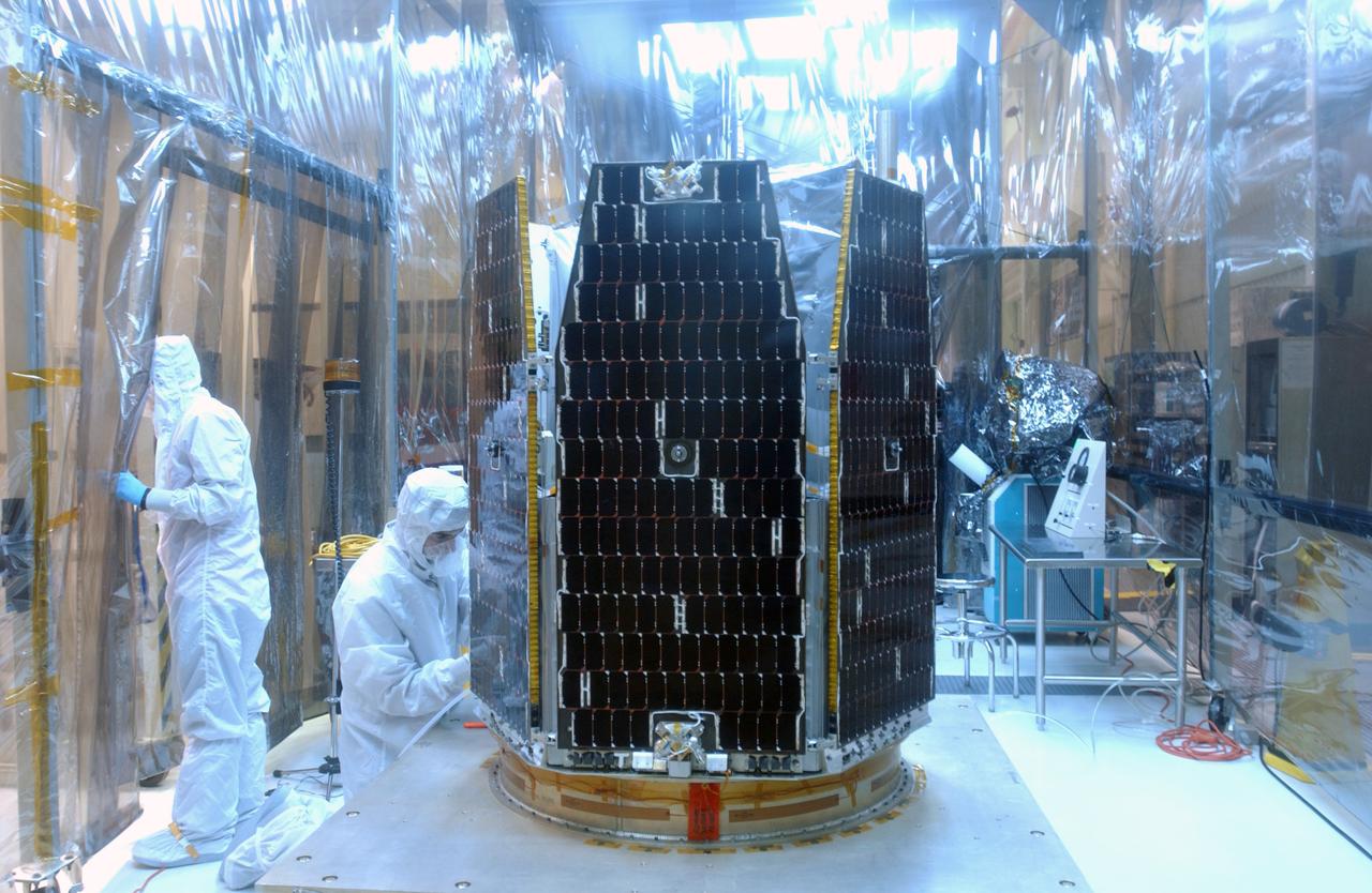 Inside the clean-room "tent" of Building 1555 at North Vandenberg Air Force Base, technicians in bunny suits prepare for the solar array deployment on the AIM spacecraft. The AIM spacecraft will fly three instruments designed to study polar mesospheric clouds located at the edge of space, 50 miles above the Earth's surface in the coldest part of the planet's atmosphere. The mission's primary goal is to explain why these clouds form and what has caused them to become brighter and more numerous and appear at lower latitudes in recent years. AIM's results will provide the basis for the study of long-term variability in the mesospheric climate and its relationship to global climate change. AIM is scheduled to be mated to the Pegasus XL during the second week of April, after which final inspections will be conducted. Launch is scheduled for April 25.
