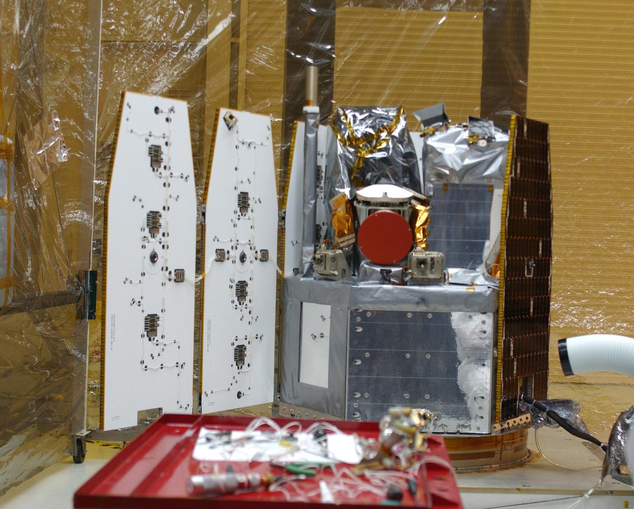 Inside the clean-room "tent" of Building 1555 at North Vandenberg Air Force Base, two of the solar array panels on the AIM spacecraft are deployed for testing. Inside are the instruments that will study polar mesospheric clouds located at the edge of space. The AIM spacecraft will fly three instruments designed to study those clouds located at the edge of space, 50 miles above the Earth's surface in the coldest part of the planet's atmosphere. The mission's primary goal is to explain why these clouds form and what has caused them to become brighter and more numerous and appear at lower latitudes in recent years. AIM's results will provide the basis for the study of long-term variability in the mesospheric climate and its relationship to global climate change. AIM is scheduled to be mated to the Pegasus XL during the second week of April, after which final inspections will be conducted. Launch is scheduled for April 25.
