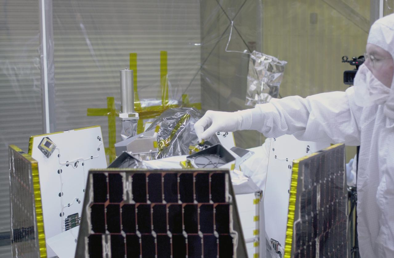 In a clean-room environment at North Vandenberg Air Force Base, technicians remove covers from instruments in the AIM spacecraft while solar panels are partially deployed. The AIM spacecraft will fly three instruments designed to study polar mesospheric clouds located at the edge of space, 50 miles above the Earth's surface in the coldest part of the planet's atmosphere. The mission's primary goal is to explain why these clouds form and what has caused them to become brighter and more numerous and appear at lower latitudes in recent years. AIM's results will provide the basis for the study of long-term variability in the mesospheric climate and its relationship to global climate change. AIM is scheduled to be mated to the Pegasus XL during the second week of April, after which final inspections will be conducted. Launch is scheduled for April 25.