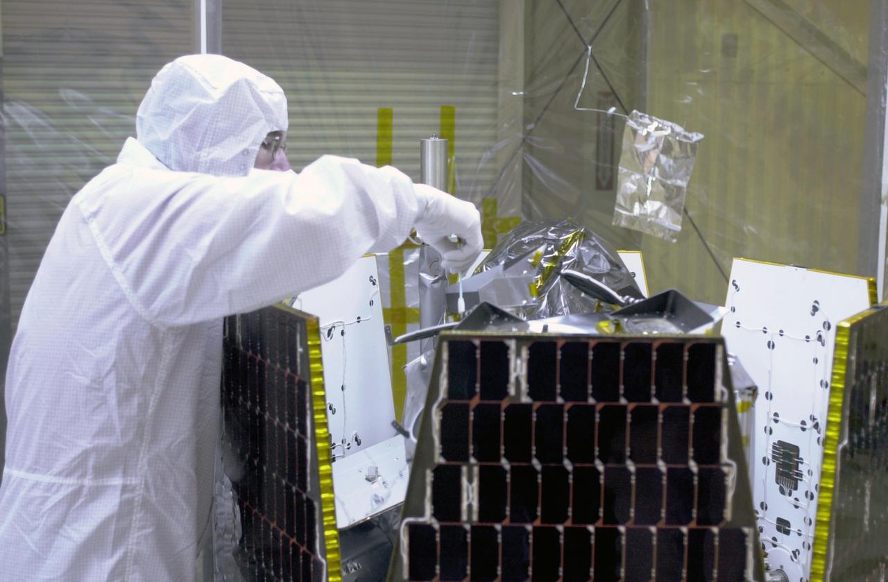 In a clean-room environment at North Vandenberg Air Force Base, technicians remove covers from instruments in the AIM spacecraft while solar panels are partially deployed. AIM will fly three instruments designed to study polar mesospheric clouds located at the edge of space, 50 miles above the Earth's surface in the coldest part of the planet's atmosphere. The mission's primary goal is to explain why these clouds form and what has caused them to become brighter and more numerous and appear at lower latitudes in recent years. AIM's results will provide the basis for the study of long-term variability in the mesospheric climate and its relationship to global climate change. AIM is scheduled to be mated to the Pegasus XL during the second week of April, after which final inspections will be conducted. Launch is scheduled for April 25.