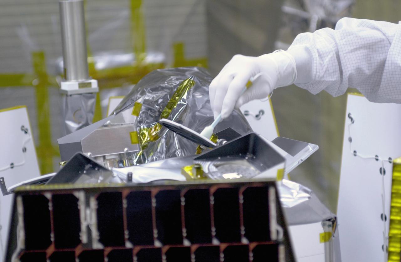 In a clean-room environment at North Vandenberg Air Force Base, technicians remove covers from instruments in the AIM spacecraft while solar panels are partially deployed. AIM will fly three instruments designed to study polar mesospheric clouds located at the edge of space, 50 miles above the Earth's surface in the coldest part of the planet's atmosphere. The mission's primary goal is to explain why these clouds form and what has caused them to become brighter and more numerous and appear at lower latitudes in recent years. AIM's results will provide the basis for the study of long-term variability in the mesospheric climate and its relationship to global climate change. AIM is scheduled to be mated to the Pegasus XL during the second week of April, after which final inspections will be conducted. Launch is scheduled for April 25.