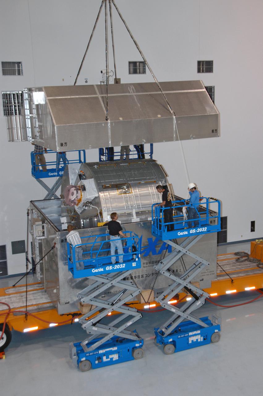 Inside the Space Station Processing Facility, workers monitor progress as a huge crane is used to remove the top of the crate carrying the Experiment Logistics Module Pressurized Section for the Japanese Experiment Module. The logistics module is one of the components of the Japanese Experiment Module or JEM, also known as Kibo, which means "hope" in Japanese. Kibo comprises six components: two research facilities -- the Pressurized Module and Exposed Facility; a Logistics Module attached to each of them; a Remote Manipulator System; and an Inter-Orbit Communication System unit. Kibo also has a scientific airlock through which experiments are transferred and exposed to the external environment of space. Kibo is Japan's first human space facility and its primary contribution to the station. Kibo will enhance the unique research capabilities of the orbiting complex by providing an additional environment in which astronauts can conduct science experiments. The various components of JEM will be assembled in space over the course of three Space Shuttle missions. The first of those three missions, STS-123, will carry the Experiment Logistics Module Pressurized Section aboard the Space Shuttle Endeavour, targeted for launch in 2007. 