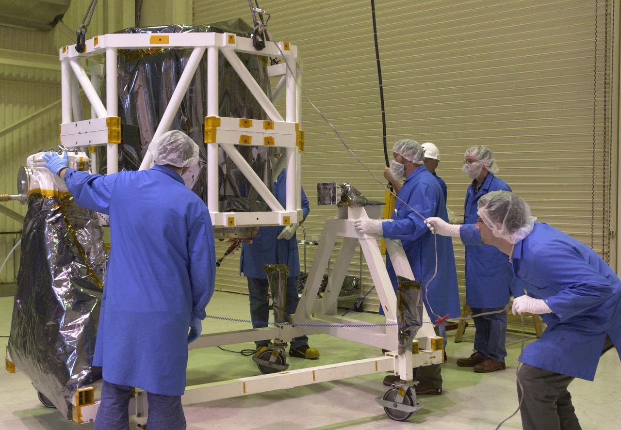 In Building 1555 on North Vandenberg Air Force Base in California, technicians lower the AIM spacecraft onto a moveable stand. AIM, which stands for Aeronomy of Ice in the Mesosphere, is being prepared for integrated testing and a flight simulation. The AIM spacecraft will fly three instruments designed to study polar mesospheric clouds located at the edge of space, 50 miles above the Earth's surface in the coldest part of the planet's atmosphere. The mission's primary goal is to explain why these clouds form and what has caused them to become brighter and more numerous and appear at lower latitudes in recent years. AIM's results will provide the basis for the study of long-term variability in the mesospheric climate and its relationship to global climate change. AIM is scheduled to be mated to its launch vehicle, Orbital Sciences' Pegasus XL, during the second week of April, after which final inspections will be conducted. Launch is scheduled for April 25.