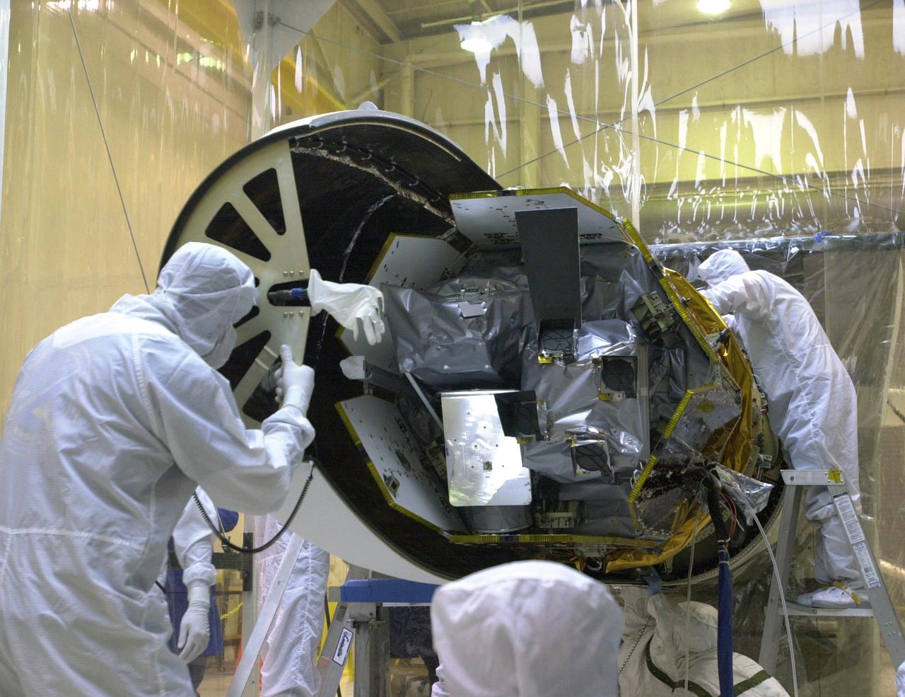 At Vandenberg Air Force Base in California, technicians prepare the AIM spacecraft for fairing installation. The fairing is a molded structure that fits around the spacecraft and forms an aerodynamically smooth nose cone, protecting the spacecraft during launch. Launch will be from a Pegasus XL rocket, carried and released by Orbital Sciences L-1011 jet aircraft. AIM, which stands for Aeronomy of Ice in the Mesosphere, is being prepared for integrated testing and a flight simulation. The AIM spacecraft will fly three instruments designed to study polar mesospheric clouds located at the edge of space, 50 miles above the Earth's surface in the coldest part of the planet's atmosphere. The mission's primary goal is to explain why these clouds form and what has caused them to become brighter and more numerous and appear at lower latitudes in recent years. AIM's results will provide the basis for the study of long-term variability in the mesospheric climate and its relationship to global climate change. Launch is scheduled for April 25.