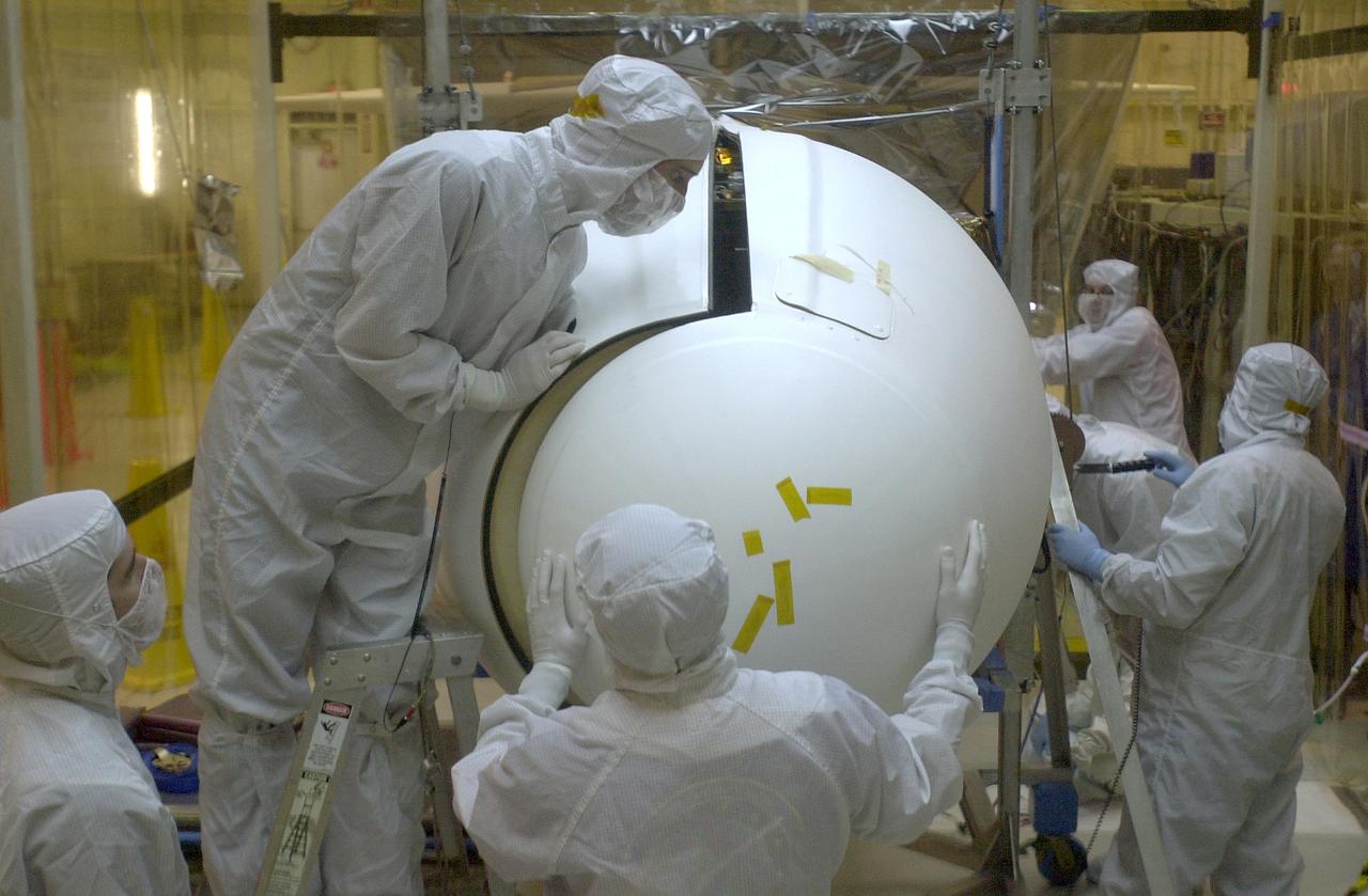 At Vandenberg Air Force Base in California, under the protective clean tent, technicians maneuver the second half of the fairing into place around the AIM spacecraft. The fairing is a molded structure that fits around the spacecraft and forms an aerodynamically smooth nose cone, protecting the spacecraft during launch. Launch will be from a Pegasus XL rocket, carried and released by Orbital Sciences L-1011 jet aircraft. AIM, which stands for Aeronomy of Ice in the Mesosphere, is being prepared for integrated testing and a flight simulation. The AIM spacecraft will fly three instruments designed to study polar mesospheric clouds located at the edge of space, 50 miles above the Earth's surface in the coldest part of the planet's atmosphere. The mission's primary goal is to explain why these clouds form and what has caused them to become brighter and more numerous and appear at lower latitudes in recent years. AIM's results will provide the basis for the study of long-term variability in the mesospheric climate and its relationship to global climate change. Launch is scheduled for April 25.