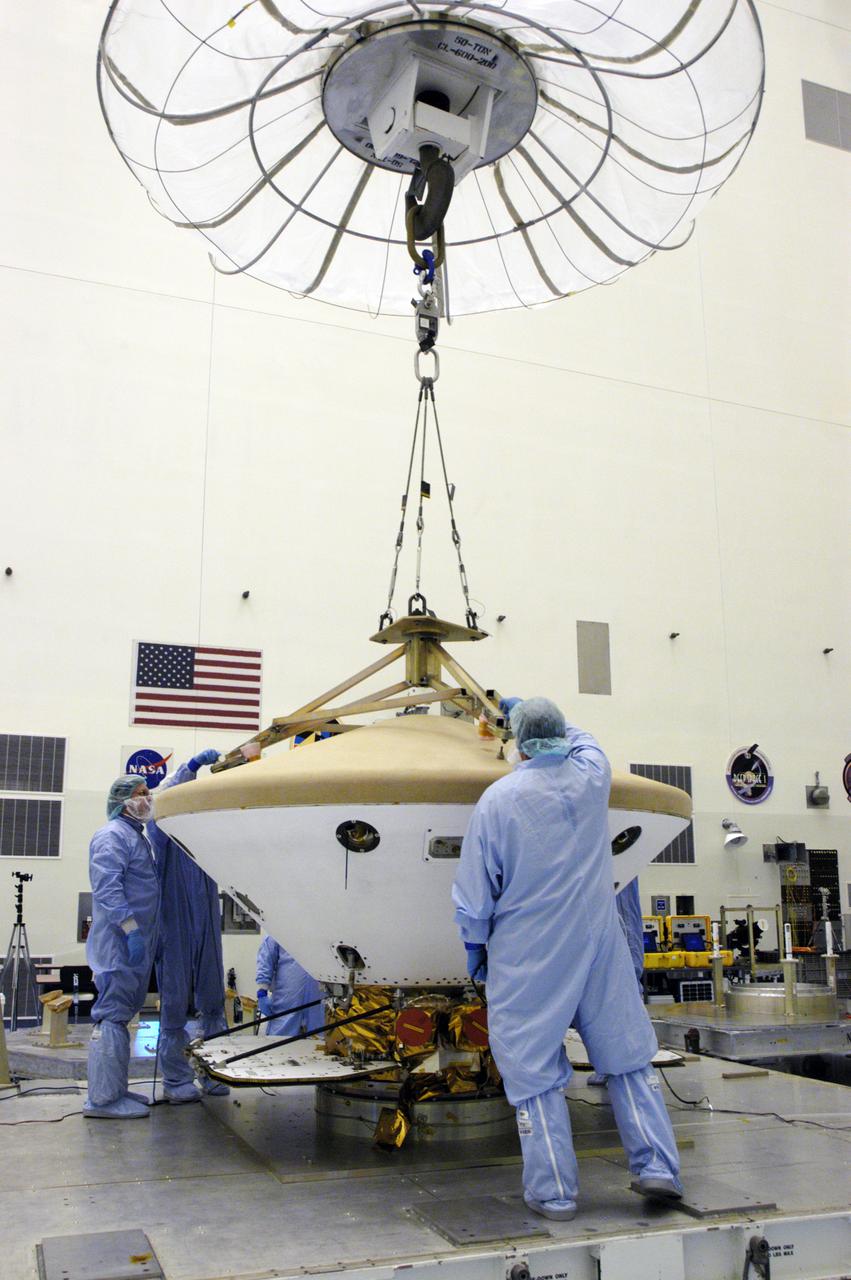 In the Payload Hazardous Servicing Facility, technicians attach a crane to the Phoenix Mars Lander spacecraft. The crane will be used to remove the heat shield from around the Phoenix. The Phoenix mission is the first project in NASA's first openly competed program of Mars Scout missions. Phoenix will land in icy soils near the north polar permanent ice cap of Mars and explore the history of the water in these soils and any associated rocks, while monitoring polar climate. Landing is planned in May 2008 on arctic ground where a mission currently in orbit, Mars Odyssey, has detected high concentrations of ice just beneath the top layer of soil. It will serve as NASA's first exploration of a potential modern habitat on Mars and open the door to a renewed search for carbon-bearing compounds, last attempted with NASA’s Viking missions in the 1970s. A stereo color camera and a weather station will study the surrounding environment while the other instruments check excavated soil samples for water, organic chemicals and conditions that could indicate whether the site was ever hospitable to life. Microscopes can reveal features as small as one one-thousandth the width of a human hair. Launch of Phoenix aboard a Delta II rocket is targeted for Aug. 3 from Cape Canaveral Air Force Station in Florida.