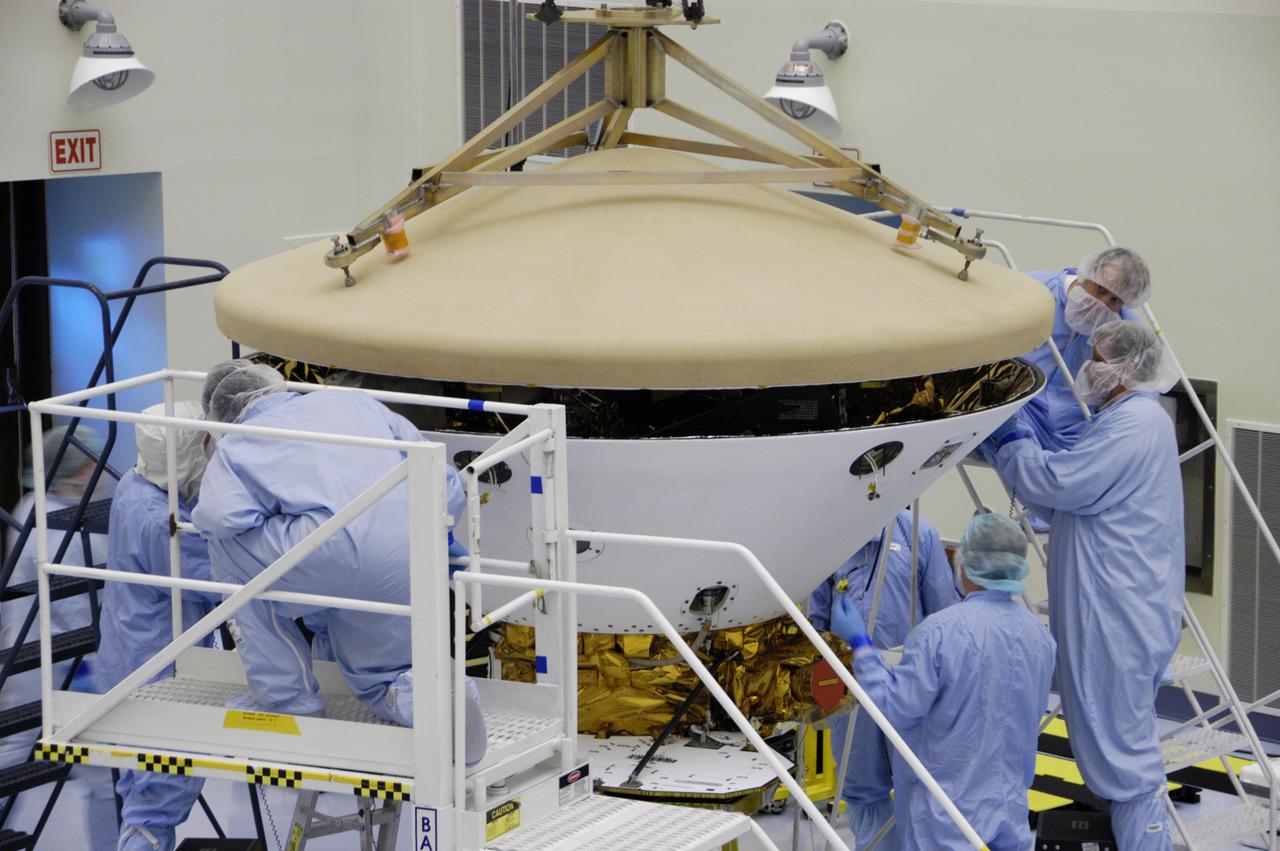 In the Payload Hazardous Servicing Facility, technicians prepare to install the heat shield on the Phoenix Mars Lander spacecraft. The Phoenix mission is the first project in NASA's first openly competed program of Mars Scout missions. Phoenix will land in icy soils near the north polar permanent ice cap of Mars and explore the history of the water in these soils and any associated rocks, while monitoring polar climate. Landing is planned in May 2008 on arctic ground where a mission currently in orbit, Mars Odyssey, has detected high concentrations of ice just beneath the top layer of soil. It will serve as NASA's first exploration of a potential modern habitat on Mars and open the door to a renewed search for carbon-bearing compounds, last attempted with NASA's Viking missions in the 1970s. A stereo color camera and a weather station will study the surrounding environment while the other instruments check excavated soil samples for water, organic chemicals and conditions that could indicate whether the site was ever hospitable to life. Microscopes can reveal features as small as one one-thousandth the width of a human hair. Launch of Phoenix aboard a Delta II rocket is targeted for Aug. 3 from Cape Canaveral Air Force Station in Florida.