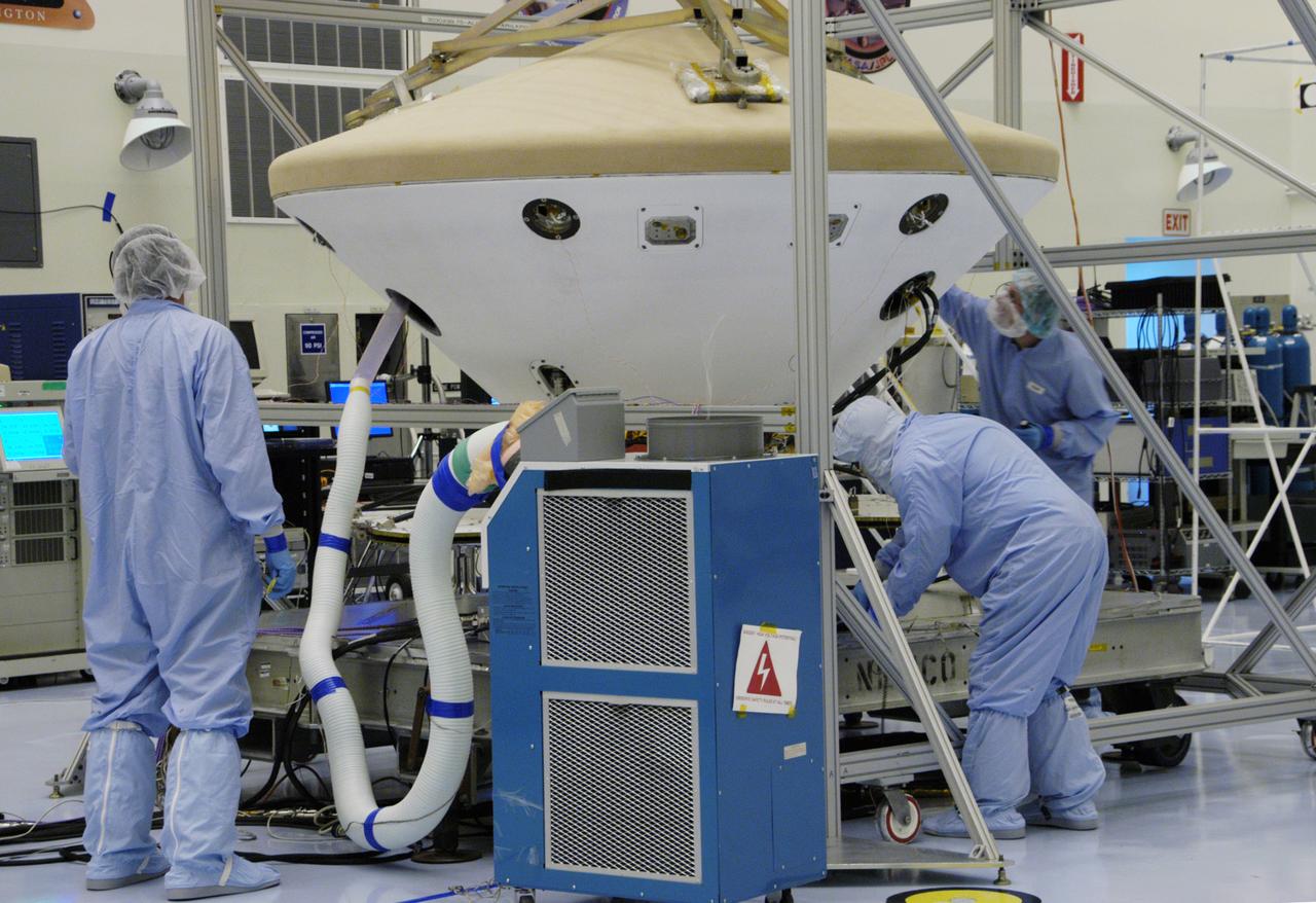 In the Payload Hazardous Servicing Facility, workers monitor the Phoenix spacecraft during a heat shield deployment test, with a firing of ordnance associated with the separation device. Phoenix will land in icy soils near the north polar permanent ice cap of Mars and explore the history of the water in these soils and any associated rocks, while monitoring polar climate. Landing is planned in May 2008 on arctic ground where a mission currently in orbit, Mars Odyssey, has detected high concentrations of ice just beneath the top layer of soil. Launch of Phoenix aboard a Delta II rocket is targeted for Aug. 3 from Cape Canaveral Air Force Station in Florida.