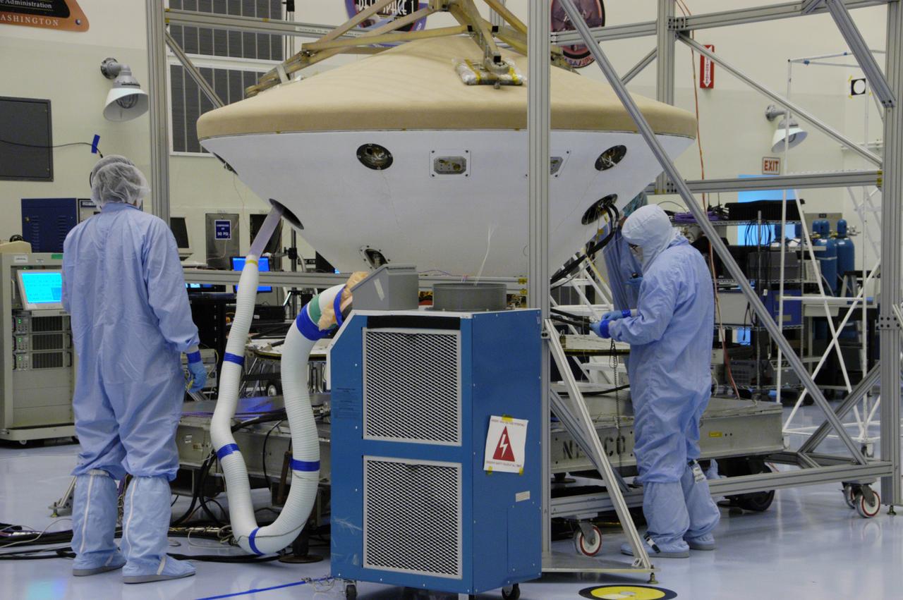 In the Payload Hazardous Servicing Facility, workers monitor the Phoenix spacecraft during a heat shield deployment test, with a firing of ordnance associated with the separation device. Phoenix will land in icy soils near the north polar permanent ice cap of Mars and explore the history of the water in these soils and any associated rocks, while monitoring polar climate. Landing is planned in May 2008 on arctic ground where a mission currently in orbit, Mars Odyssey, has detected high concentrations of ice just beneath the top layer of soil. Launch of Phoenix aboard a Delta II rocket is targeted for Aug. 3 from Cape Canaveral Air Force Station in Florida.