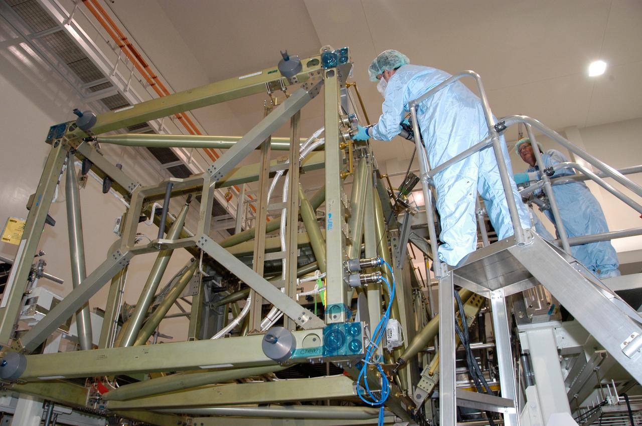 In the Space Station Processing Facility at NASA's Kennedy Space Center, a worker connects a cable to recharge the battery for the S6 integrated truss. The final starboard truss in the assembly of the International Space Station, the S6 is scheduled to fly on space shuttle mission STS-119, whose launch date is not yet determined.