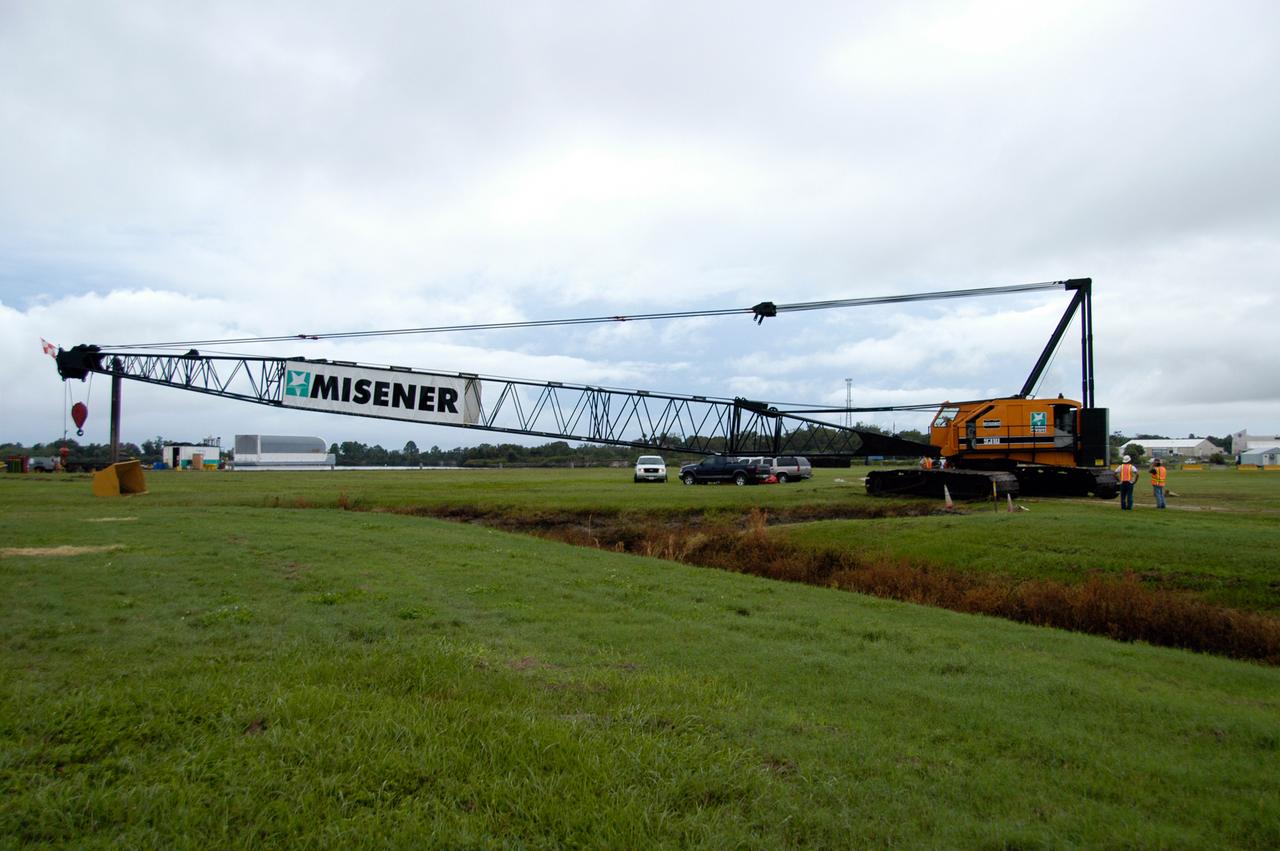 A large crawler crane begins moving away from the turn basin at the Launch Complex 39 Area on NASA's Kennedy Space Center. The crane with its 70-foot boom will be moved to Launch Pad 39B and used to construct a new lightning protection system for the Constellation Program and Ares/Orion launches. Pad B will be the site of the first Ares vehicle launch, including Ares I-X which is scheduled for April 2009.