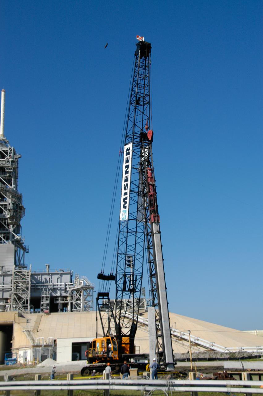On Launch Pad 39B at NASA's Kennedy Space Center, the crane crawler lifts a piling into place to be pounded into the ground to help construct lightning towers for the Constellation Program and Ares/Orion launches. Pad B will be the site of the first Ares vehicle launch, including Ares I-X which is scheduled for April 2009.