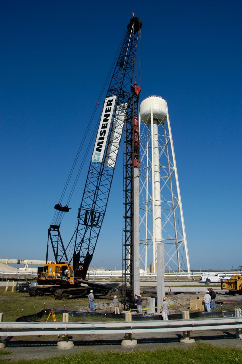 On Launch Pad 39B at NASA's Kennedy Space Center, the crane crawler puts a piling into place to be pounded into the ground to help construct lightning towers for the Constellation Program and Ares/Orion launches. Pad B will be the site of the first Ares vehicle launch, including Ares I-X which is scheduled for April 2009.