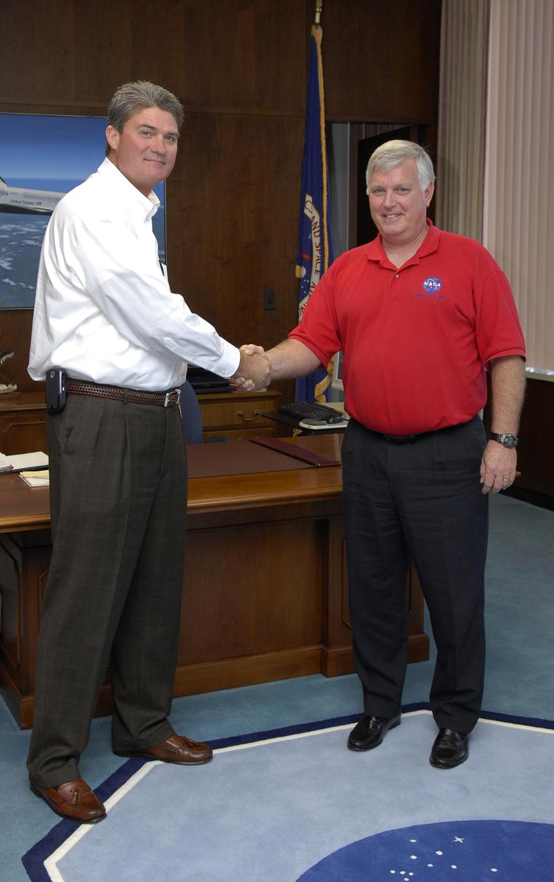 KENNEDY SPACE CENTER, FLA. -- A handshake signifies the change of leadership at NASA's Kennedy Space Center as William W. Parsons (left) assumes the role as the facility's ninth director, succeeding James W. Kennedy (right), who is retiring from the agency.  Photo credit: NASA/Kim Shiflett