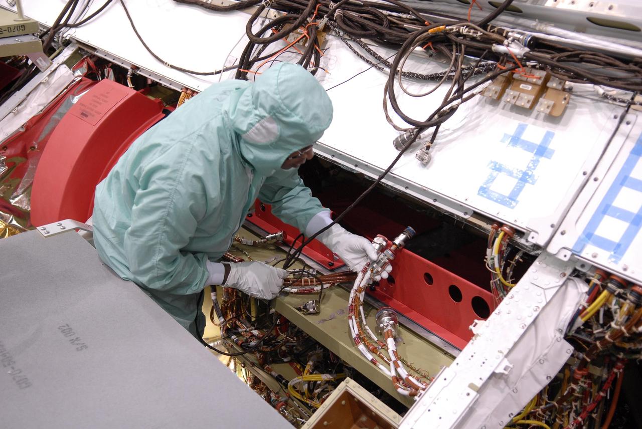 KENNEDY SPACE CENTER, FLA. --   Inside Endeavour's opened payload bay, a worker installs a wiring modification called the "Station to Shuttle Power Transfer System," or SSPTS. The SSPTS allows the space shuttle to stay docked at the International Space Station longer by providing its power and preserving its consumables.  Endeavour is scheduled for mission STS-118 in June.  It will be the orbiter's first shuttle flight in nearly five years. The vehicle has undergone an extensive modification period, including the addition of all of the return-to-flight safety modifications added to both Discovery and Atlantis.  The June mission will deliver another starboard solar array, S5, to the International Space Station.  Photo credit: NASA/Kim Shiflett