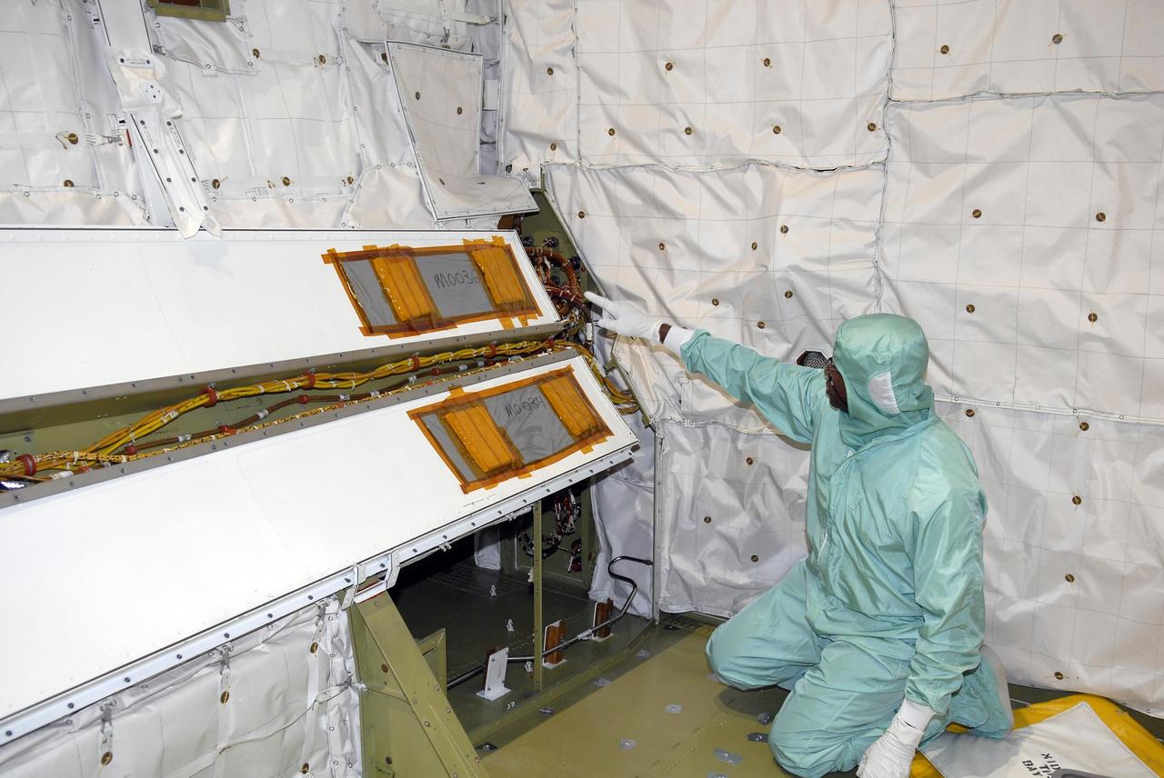 KENNEDY SPACE CENTER, FLA. --  Inside Endeavour's opened payload bay, a worker checks the installation of the wiring modification called the "Station to Shuttle Power Transfer System," or SSPTS. The SSPTS allows the space shuttle to stay docked at the International Space Station longer by providing its power and preserving its consumables.  Endeavour is scheduled for mission STS-118 in June.  It will be the orbiter's first shuttle flight in nearly five years. The vehicle has undergone an extensive modification period, including the addition of all of the return-to-flight safety modifications added to both Discovery and Atlantis.  The June mission will deliver another starboard solar array, S5, to the International Space Station.  Photo credit: NASA/Kim Shiflett