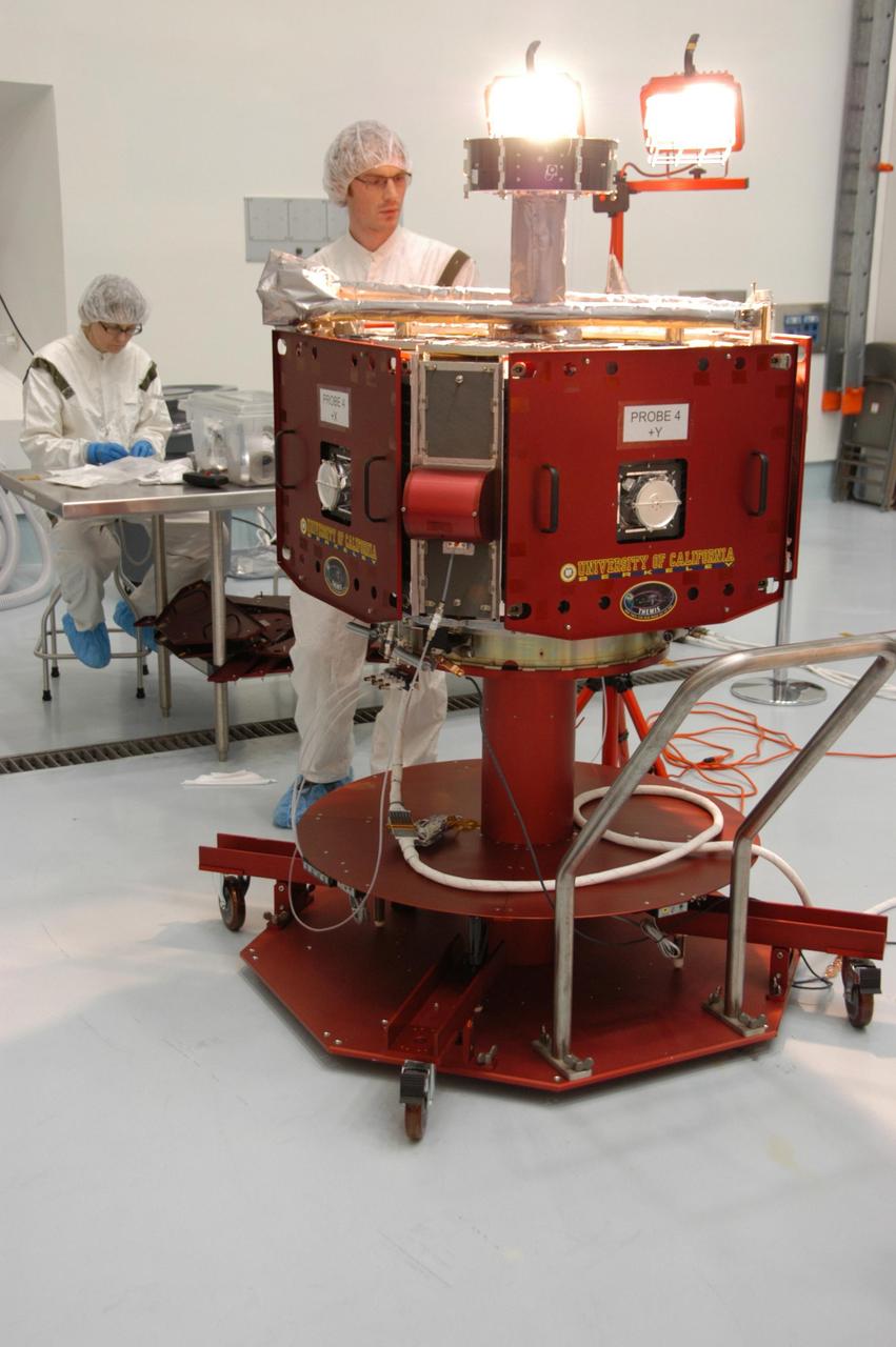 KENNEDY SPACE CENTER, FLA. -- In the Hazardous Processing Facility at Astrotech Space Operations, a technician observes one of the THEMIS probes as it undergoes solar array illumination telemetry testing. THEMIS consists of five identical probes, the largest number of scientific satellites ever launched into orbit aboard a single rocket. This unique constellation of satellites will resolve the tantalizing mystery of what causes the spectacular sudden brightening of the aurora borealis and aurora australis - the fiery skies over the Earth's northern and southern polar regions. THEMIS is scheduled to launch aboard the Delta II at 6:07 p.m. EST on Feb. 15. Photo credit: NASA/George Shelton
