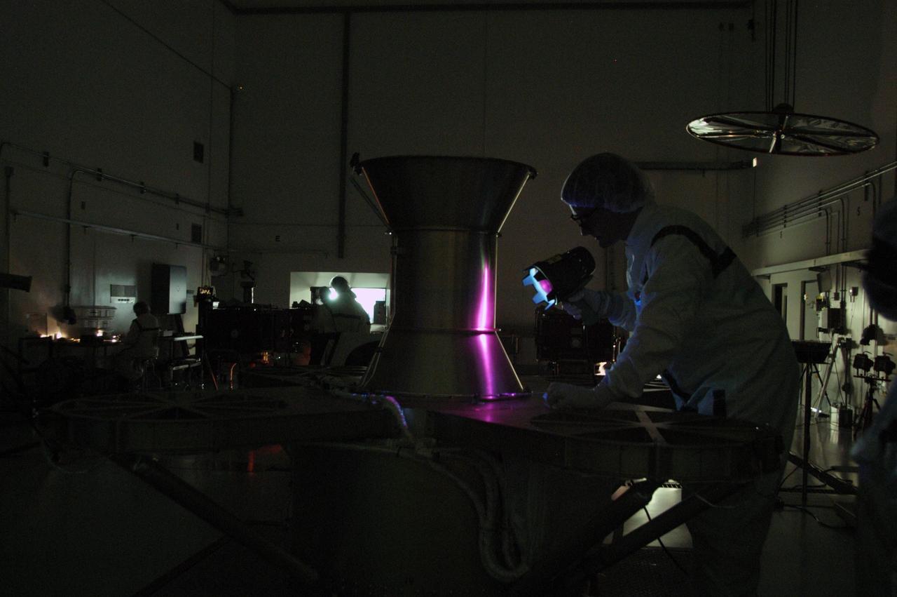KENNEDY SPACE CENTER, FLA. --  At Astrotech Space Operations, technicians conduct black light inspection of the THEMIS probes.  Black light inspection uses UVA fluorescence to detect possible particulate microcontamination, minute cracks or fluid leaks.  THEMIS consists of five identical probes, the largest number of scientific satellites ever launched into orbit aboard a single rocket. This unique constellation of satellites will resolve the tantalizing mystery of what causes the spectacular sudden brightening of the aurora borealis and aurora australis - the fiery skies over the Earth's northern and southern polar regions. THEMIS is scheduled to launch Feb. 15 from Cape Canaveral Air Force Station.  Photo credit: NASA/George Shelton