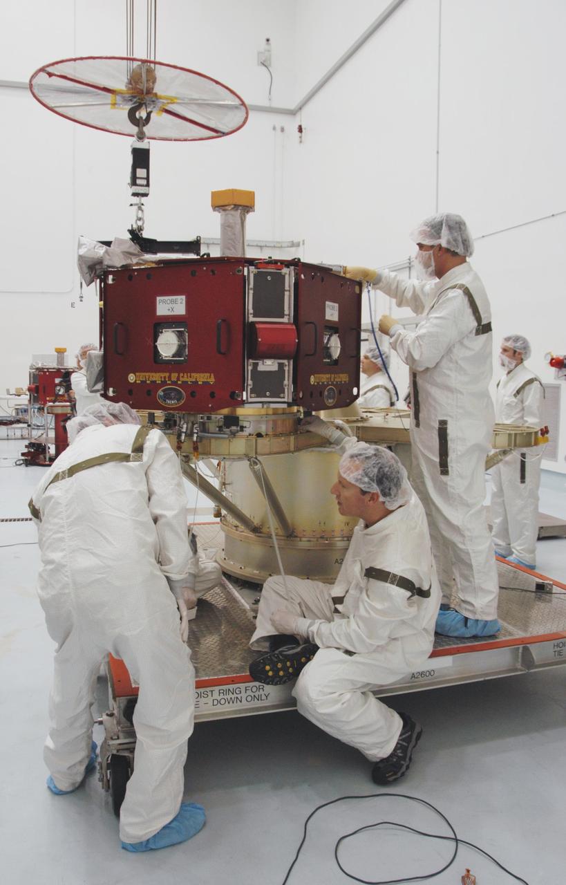 KENNEDY SPACE CENTER, FLA. -- At Astrotech Space Operations, technicians guide one of the THEMIS probes into position on the probe carrier. When all five probes are in place, the carrier will undergo spin-balance testing. THEMIS consists of five identical probes, the largest number of scientific satellites ever launched into orbit aboard a single rocket. This unique constellation of satellites will resolve the tantalizing mystery of what causes the spectacular sudden brightening of the aurora borealis and aurora australis - the fiery skies over the Earth's northern and southern polar regions. THEMIS is scheduled to launch Feb. 15 from Cape Canaveral Air Force Station. Photo credit: NASA/George Shelton