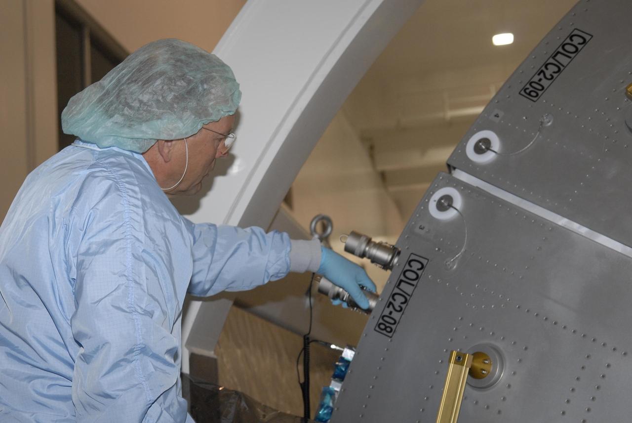 KENNEDY SPACE CENTER, FLA. --  In the Space Station Processing Facility, STS-122 crew members inspect the Columbus European Laboratory, part of the payload on their mission.  Seen here is Commander Steve Frick. The crew is participating in a crew equipment interface test that provides opportunities for hands-on experience with payloads and equipment.  The other crew members are Pilot Alan Poindexter and Mission Specialists Rex Walheim, Stan Love, Leland Melvin and Hans Schlegel, who represents the European Space Agency. The 24th mission to the International Space Station, STS-122 will also include the Multi-Purpose Experiment Support Structure - Non-Deployable (MPESS-ND). Launch of STS-122 on Space Shuttle Discovery is scheduled no earlier than October. Photo credit: NASA/Kim Shiflett