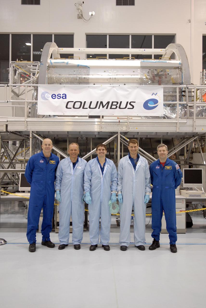 KENNEDY SPACE CENTER, FLA. -- In the Space Station Processing Facility, STS-122 crew members pause for a photo in front of the Columbus European Laboratory, part of the payload on their mission. From left are Pilot Alan Poindexter, Mission Specialists Hans Schlegel, Rex Walheim and Stan Love, and Commander Steve Frick. Schlegel represents the European Space Agency. The crew is participating in a crew equipment interface test that provides opportunities for hands-on experience with payloads and equipment. The 24th mission to the International Space Station, STS-122 will also include the Multi-Purpose Experiment Support Structure - Non-Deployable (MPESS-ND). Launch of STS-122 on Space Shuttle Discovery is scheduled no earlier than October. Photo credit: NASA/Kim Shiflett