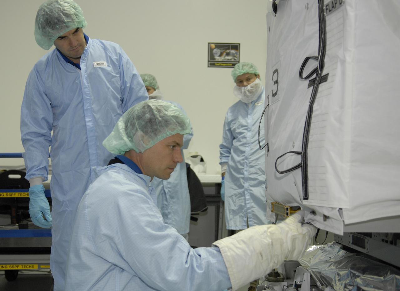 KENNEDY SPACE CENTER, FLA. -- In the Space Station Processing Facility, STS-122 crew members inspect the Multi-Purpose Experiment Support Structure - Non-Deployable (MPESS-ND), part of the payload on their mission. In the foreground are Mission Specialists Rex Walheim (left) and Stan Love.  The crew is participating in a crew equipment interface test that provides opportunities for hands-on experience with payloads and equipment.  The other crew members are Commander Steve Frick, Pilot Alan Poindexter and Mission Specialists Leland Melvin and Hans Schlegel, who represents the European Space Agency. The 24th mission to the International Space Station, STS-122 will also include the Columbus European Laboratory. Launch of STS-122 on Space Shuttle Discovery is scheduled no earlier than October. Photo credit: NASA/Kim Shiflett