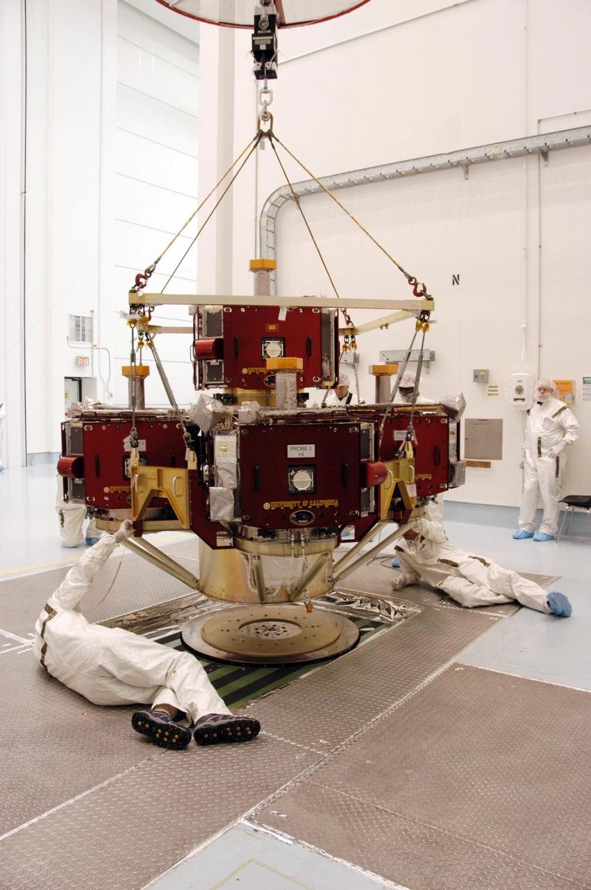 KENNEDY SPACE CENTER, FLA. --   In the Hazardous Processing Facility at Astrotech Space Operations, workers guide the integrated THEMIS spacecraft onto the spin table in the foreground.  There it will undergo spin-balance testing. THEMIS consists of five identical probes, the largest number of scientific satellites ever launched into orbit aboard a single rocket. This unique constellation of satellites will resolve the tantalizing mystery of what causes the spectacular sudden brightening of the aurora borealis and aurora australis - the fiery skies over the Earth's northern and southern polar regions. THEMIS is scheduled to launch Feb. 15 from Cape Canaveral Air Force Station.  Photo credit: NASA/George Shelton