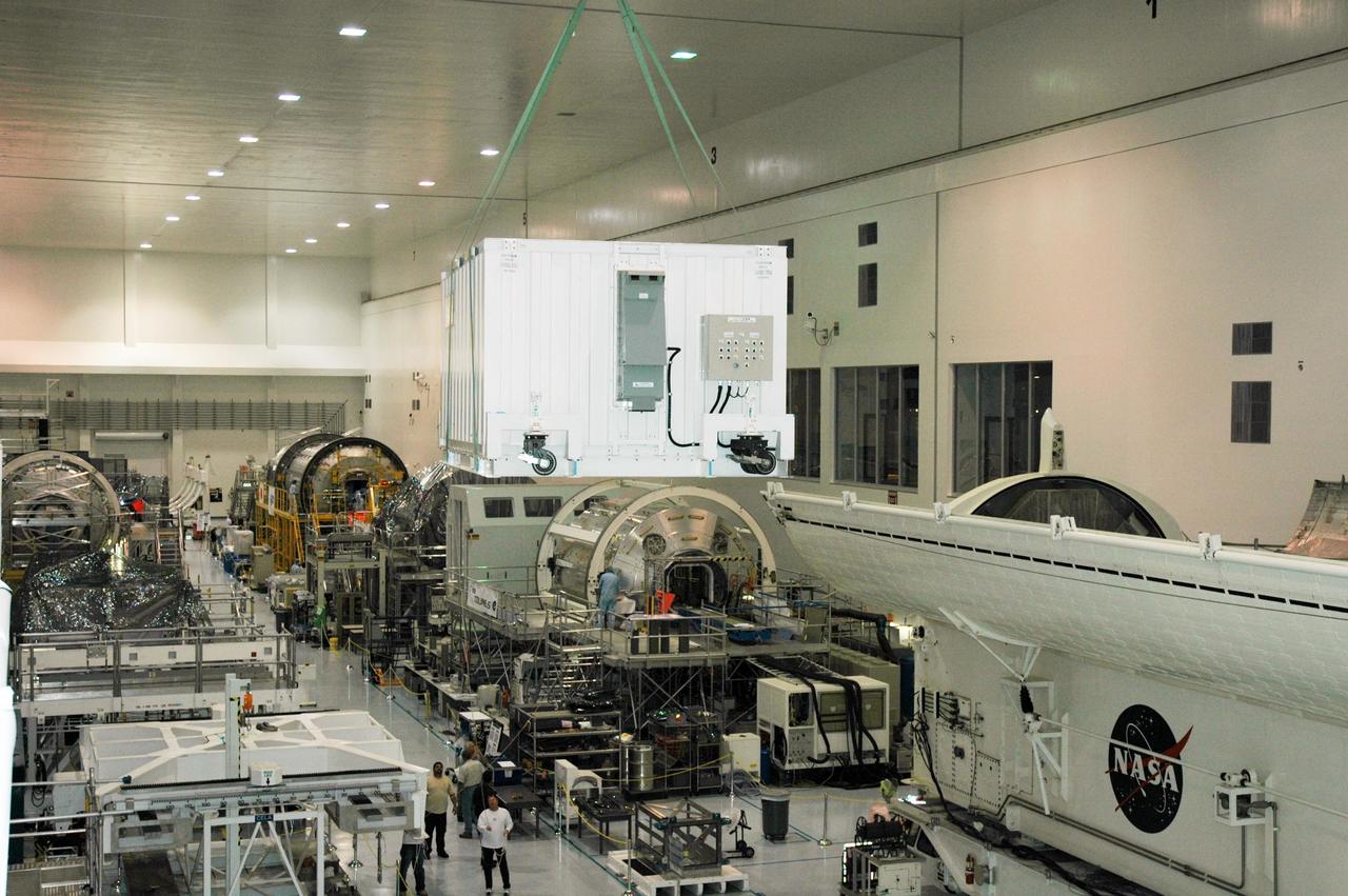 KENNEDY SPACE CENTER, FLA. -- Lifted by the overhead crane, the container with the Japanese Experiment Module (JEM) remote manipulator system inside is carried across the Space Station Processing Facility to another location. The Japanese Aerospace Exploration Agency developed the laboratory known as "Kibo" (Hope) and includes an exposed facility (platform) for space environment experiments, the RMS and two logistics modules. Japan's primary contribution to the International Space Station, it will enhance the unique research capabilities of the orbiting complex by providing an additional environment for astronauts to conduct science experiments. The various JEM components will be assembled in space over the course of three Shuttle missions. The JEM and RMS are scheduled to launch on mission STS-124 no earlier than February 2008. Photo credit: NASA/Dimitri Gerondidakis