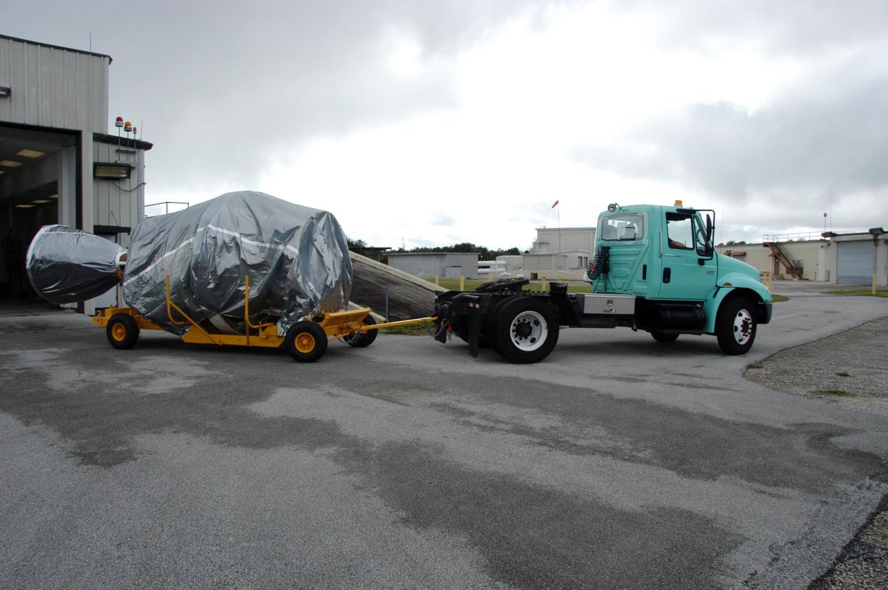 KENNEDY SPACE CENTER, FLA. -- The covered Delta II second stage arrives at a checkout hangar on Cape Canaveral Air Force Station in Florida in preparation for transfer to Pad 17-B. At the pad, it will be lifted into the mobile service tower and mated with the first stage already in place. The Delta II is the launch vehicle for the THEMIS spacecraft. THEMIS consists of five identical probes, the largest number of scientific satellites ever launched into orbit aboard a single rocket. This unique constellation of satellites will resolve the tantalizing mystery of what causes the spectacular sudden brightening of the aurora borealis and aurora australis - the fiery skies over the Earth's northern and southern polar regions. THEMIS is scheduled to launch Feb. 15 from Cape Canaveral Air Force Station. Photo credit: NASA/George Shelton