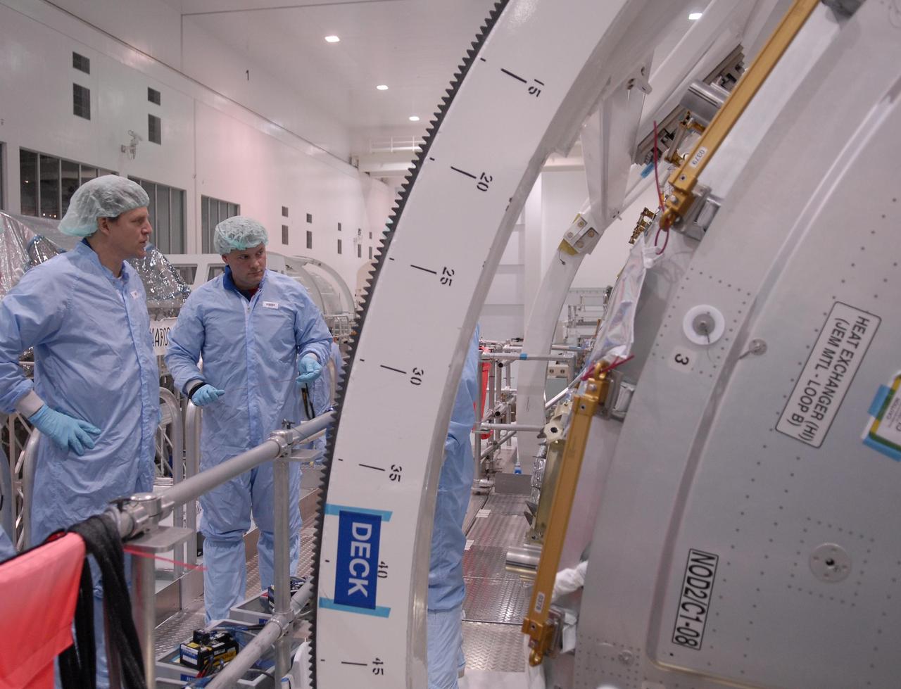KENNEDY SPACE CENTER, FLA. --  STS-120 Mission Specialists Scott Parazynski (left) and Doug Wheelock check out the primary payload for the mission: the U.S. Node 2, another element to be added to the International Space Station.  They are familiarizing themselves with the payload.  Node 2 will provide a passageway between three station science experiment facilities: the U.S. Destiny Laboratory, the Kibo Japanese Experiment Module, and the European Columbus Laboratory.  STS-120 is targeted for launch on Sept. 7 with a crew of six, including Commander Pam Melroy, Pilot George Zamka, and Mission Specialist Mike Foreman.  Photo credit: NASA/Kim Shiflett