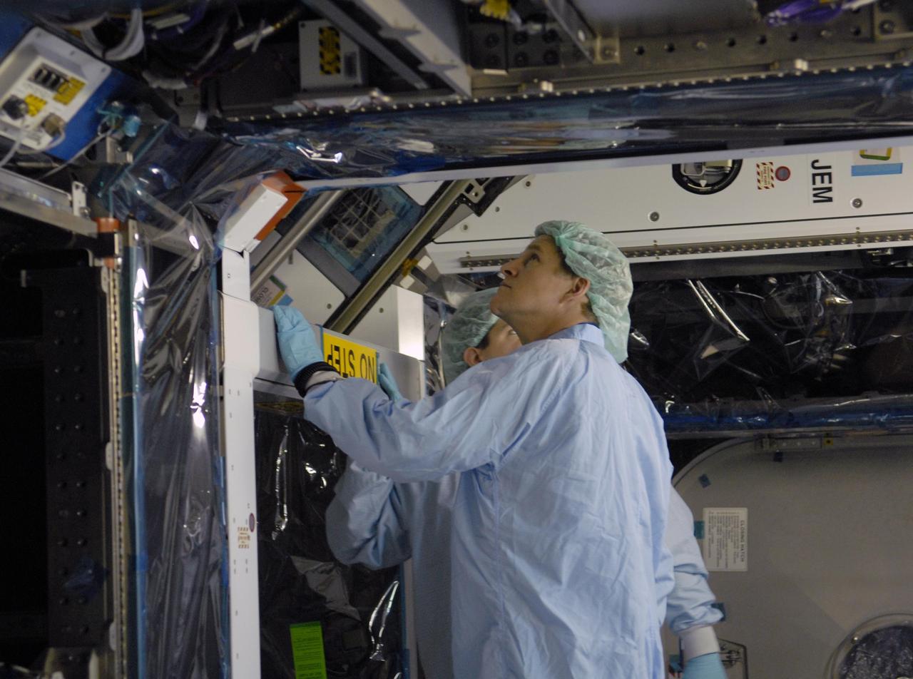 KENNEDY SPACE CENTER, FLA. --  STS-120 Mission Specialist Scott Parazynski takes a look underneath the primary payload for the mission: the U.S. Node 2, another element to be added to the International Space Station.  Node 2 will provide a passageway between three station science experiment facilities: the U.S. Destiny Laboratory, the Kibo Japanese Experiment Module, and the European Columbus Laboratory. STS-120 is targeted for launch on Sept. 7 with a crew of six, including Commander Pam Melroy, Pilot George Zamka, and Mission Specialist Mike Foreman.  Photo credit: NASA/Kim Shiflett