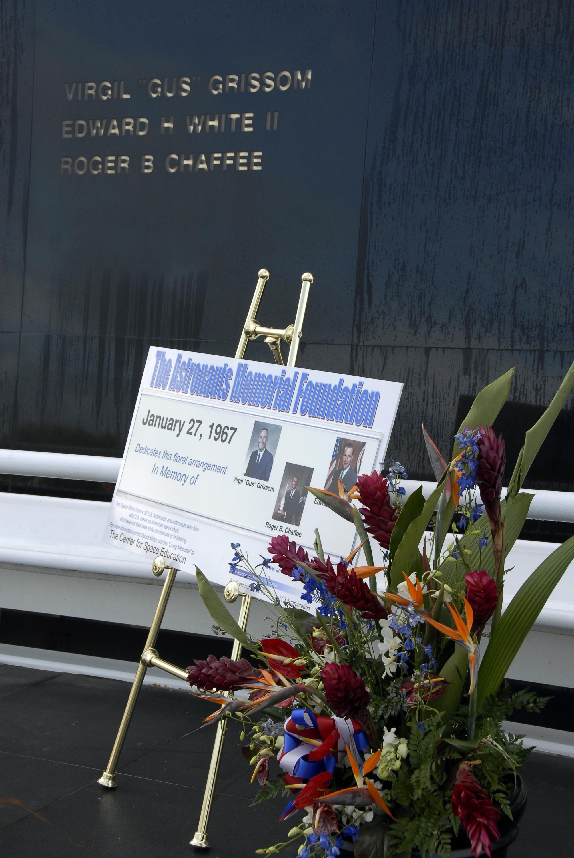 KENNEDY SPACE CENTER, FLA. --  Flowers and plaque are in place in front of the Space Mirror Memorial at the KSC Visitor Complex for the ceremony held in remembrance of the astronauts lost in the Apollo 1 fire: Virgil "Gus" Grissom, Edward H. White II and Roger B. Chaffee.  Members of their families, along with KSC Director Bill Parsons, Associate Administrator for Space Operations William Gerstenmaier, President of the Astronauts Memorial Foundation Stephen Feldman and Chairman of the Board of Directors of the Astronauts Memorial Foundation William Potter, attended the ceremony.  The mirror was designated as a national memorial by Congress and President George Bush in 1991 to honor fallen astronauts.  Their names are emblazoned on the monument’s 42-½-foot-high by 50-foot-wide black granite surface as if to be projected into the heavens.  Photo credit:NASA/Kim Shiflett