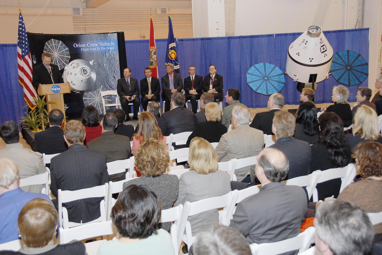 KENNEDY SPACE CENTER, FLA. -- Russell Romanella, director of the International Space Station/Payload Processing Directorate at Kennedy Space Center, addresses guests and attendees in the Operations and Checkout (O&C) Building high bay in the ceremony commemorating the bay's transition for use by the Constellation Program. Seated on the dais at right are Cleon Lacefield, Lockheed Martin program manager; Thad Altman, representative of the State of Florida; Bill Parsons, Kennedy Space Center director; Steve Koller, executive director of Space Florida; and Skip Hatfield, Orion Project manager. Originally built to process space vehicles in the Apollo era, the O&C Building will serve as the final assembly facility for the Orion crew exploration vehicle. Orion, America's human spaceflight vehicle of the future, will be capable of transporting four crewmembers for lunar missions and later will support crew transfers for Mars missions. Each Orion spacecraft also may be used to support up to six crewmembers to the International Space Station after the space shuttle is retired in 2010. Design, development and construction of Orion's components will be performed by Lockheed Martin for NASA at facilities throughout the country. Photo credit: NASA/Kim Shiflett