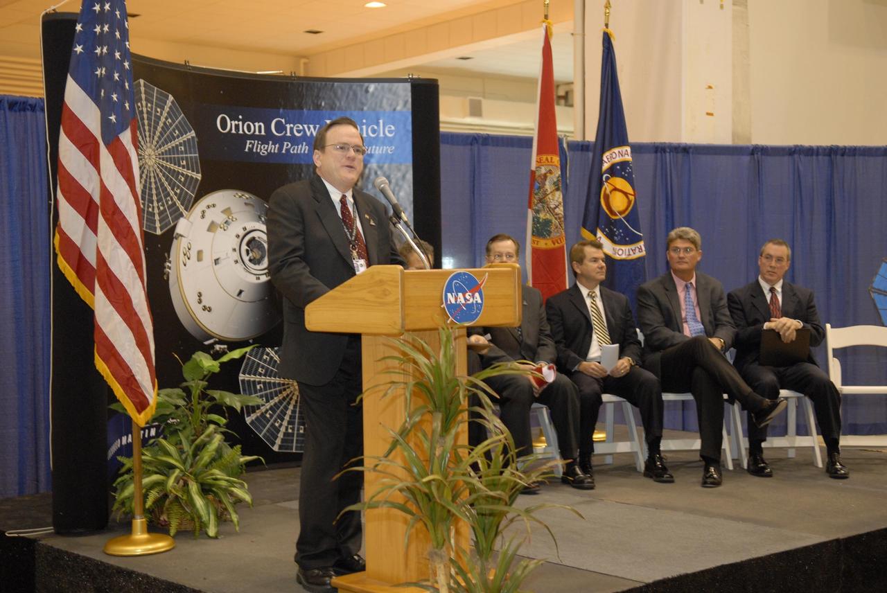 KENNEDY SPACE CENTER, FLA. -- Skip Hatfield, Orion Project manager, addresses guests and attendees in the Operations and Checkout (O&C) Building high bay in the ceremony commemorating the bay's transition for use by the Constellation Program. Seated on the dais at right are representatives from NASA, Lockheed Martin, Space Florida and the state of Florida: Russell Romanella, director of the International Space Station/Payload Processing Directorate at Kennedy Space Center, Cleon Lacefield, Lockheed Martin program manager; Thad Altman, representative of the State of Florida; Bill Parsons, director of Kennedy Space Center; and Steve Koller, executive director of Space Florida. Originally built to process space vehicles in the Apollo era, the O&C Building will serve as the final assembly facility for the Orion crew exploration vehicle. Orion, America's human spaceflight vehicle of the future, will be capable of transporting four crewmembers for lunar missions and later will support crew transfers for Mars missions. Each Orion spacecraft also may be used to support up to six crewmembers to the International Space Station after the space shuttle is retired in 2010. Design, development and construction of Orion's components will be performed by Lockheed Martin for NASA at facilities throughout the country. Photo credit: NASA/Kim Shiflett