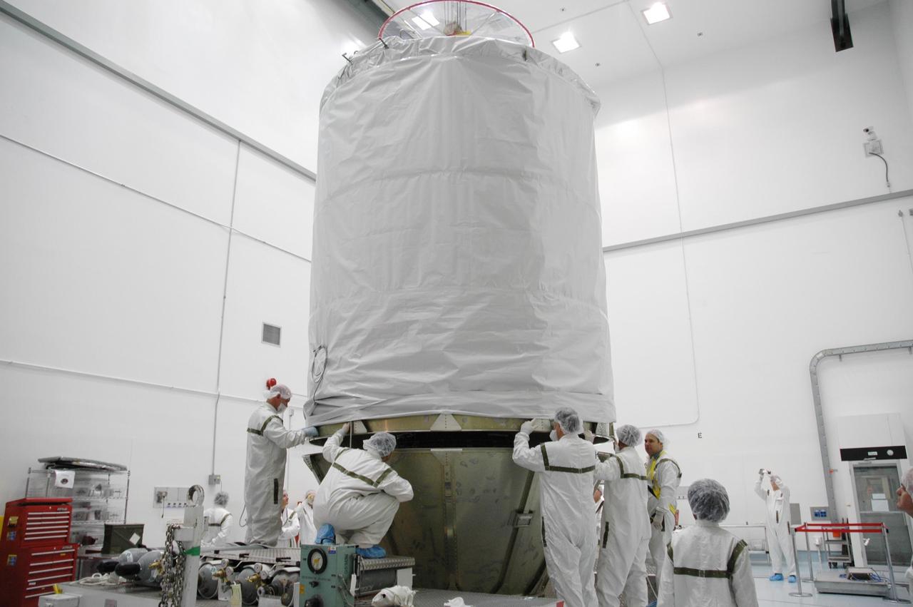 KENNEDY SPACE CENTER, FLA. --   In the high bay at Astrotech Space Operations, workers prepare to join the upper cylindrical canister to the lower panels already in place around the THEMIS spacecraft and upper stage booster.  When completely enclosed, THEMIS will be transported to Launch Complex 17-B for mating with its launch vehicle. THEMIS consists of five identical probes, the largest number of scientific satellites ever launched into orbit aboard a single rocket. This unique constellation of satellites will resolve the tantalizing mystery of what causes the spectacular sudden brightening of the aurora borealis and aurora australis - the fiery skies over the Earth's northern and southern polar regions. THEMIS is scheduled to launch Feb. 15 from Pad 17-B at Cape Canaveral Air Force Station aboard a Boeing Delta II rocket managed by the United Launch Alliance.  Photo credit: NASA/Troy Cryder