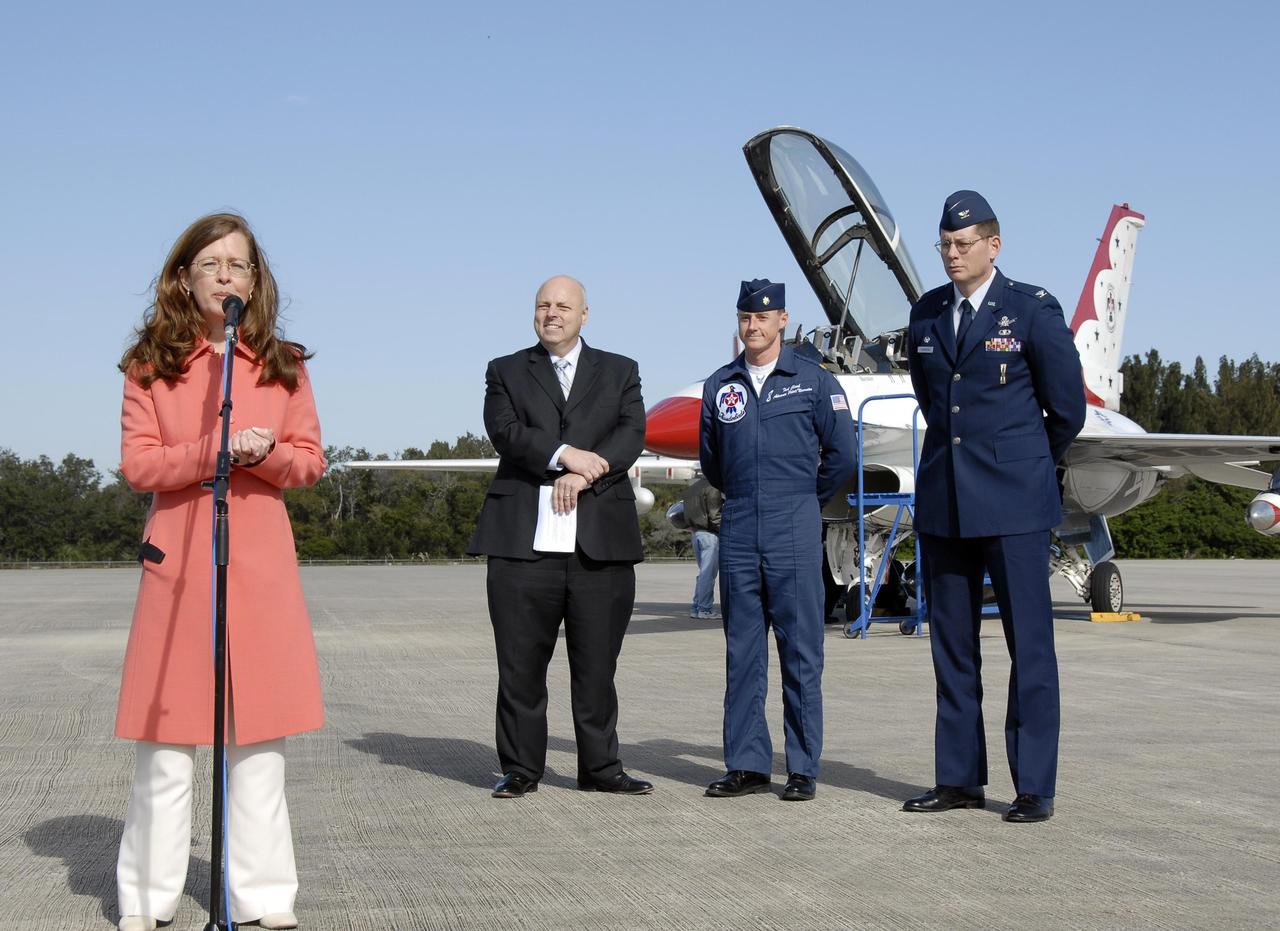 KENNEDY SPACE CENTER, FLA. --   Lisa Malone, director of External Relations at KSC, talks to the media at the KSC Shuttle Landing Facility about the arrival of Maj. Tad Clark, pilot of the U.S. Air Force Thunderbird F-16D (background). Clark flew in to KSC to announce to waiting media that the Visitor Complex will host the inaugural World Space Expo from Nov. 3 to 11. Behind Malone are (from left) Dan LeBlanc, chief operating officer of the KSC Visitor Complex, Clark, and Col. Dave Thompson with the U.S. Air Force 45th Space Wing. The Expo, which will feature an aerial salute by the Thunderbirds on its opening weekend, will create one of the largest displays of space artifacts, hardware and personalities ever assembled in one location with the objective to inspire, educate and engage the public by highlighting the achievements and benefits of space exploration.  Photo credit: NASA/Kim Shiflett