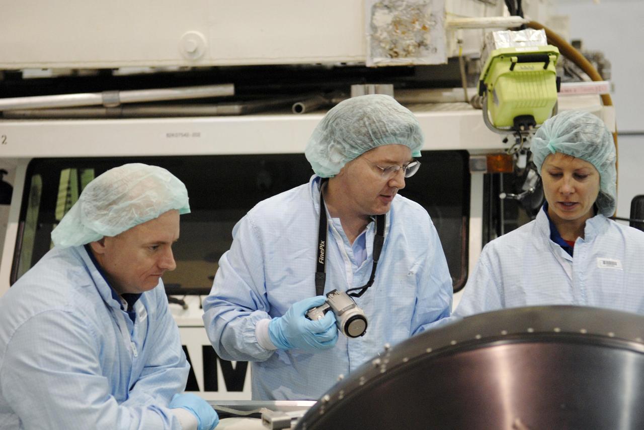 KENNEDY SPACE CENTER, FLA. -- In the Space Station Processing Facility, members of the STS-118 crew look over the control moment gyro (CMG) that is part of the payload on their mission. At left is Commander Scott Kelly; at right is Mission Specialist Tracy Caldwell. The CMG will replace a faulty one on the International Space Station. The payload also includes the SPACEHAB single cargo module, the third starboard truss segment (ITS S5) and the external stowage platform 3 (ESP3). STS-118 is targeted to launch June 28 from Launch Pad 39A. Photo credit: NASA/Kim Shiflett