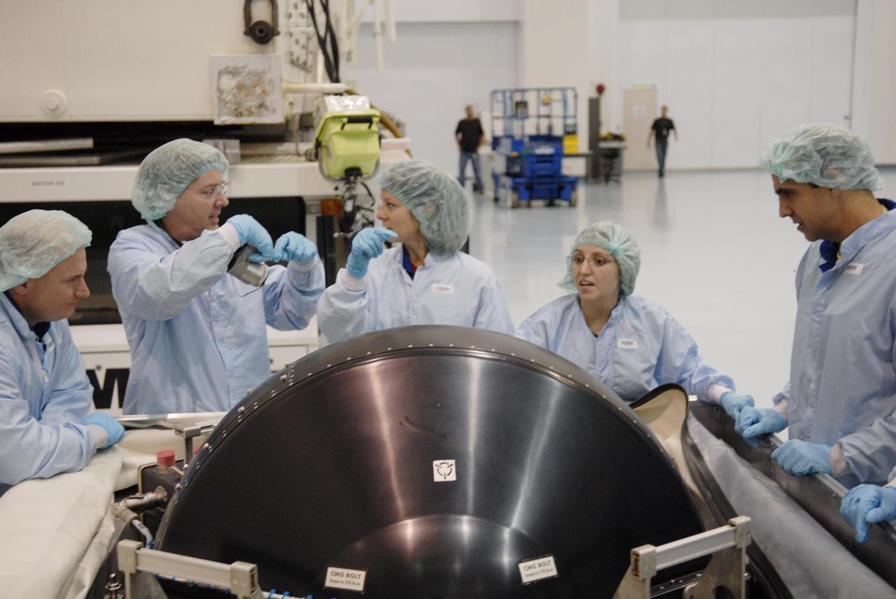 KENNEDY SPACE CENTER, FLA. -- In the Space Station Processing Facility, members of the STS-118 crew learn important information from technicians about the control moment gyro (CMG) in front of them that is part of the payload on their mission. At far left is Commander Scott Kelly; at center is Mission Specialist Tracy Caldwell; and at far right is Mission Specialist Richard Mastracchio. The CMG will replace a faulty one on the International Space Station. The payload also includes the SPACEHAB single cargo module, the third starboard truss segment (ITS S5) and the external stowage platform 3 (ESP3). STS-118 is targeted to launch June 28 from Launch Pad 39A. Photo credit: NASA/Kim Shiflett