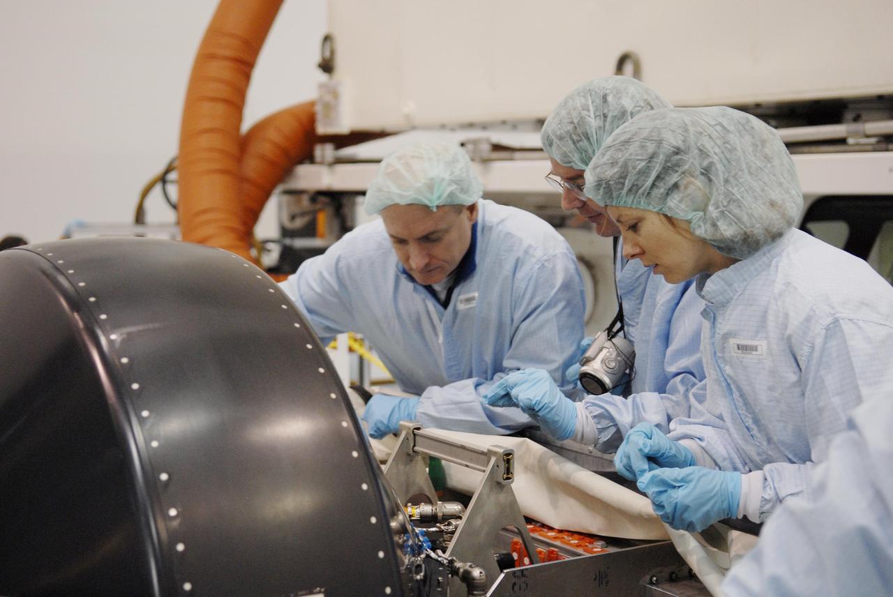 KENNEDY SPACE CENTER, FLA. -- In the Space Station Processing Facility, members of the STS-118 crew learn important information from technicians about the control moment gyro (CMG) in front of them that is part of the payload on their mission. At left is Commander Scott Kelly; at right is Mission Specialist Tracy Caldwell. The CMG will replace a faulty one on the International Space Station. The payload also includes the SPACEHAB single cargo module, the third starboard truss segment (ITS S5) and the external stowage platform 3 (ESP3). STS-118 is targeted to launch June 28 from Launch Pad 39A. Photo credit: NASA/Kim Shiflett