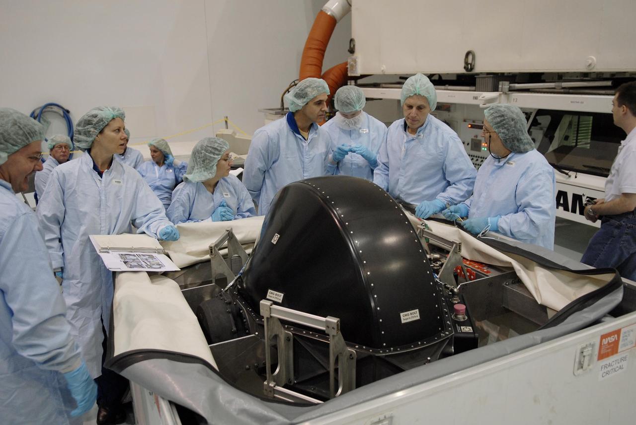 KENNEDY SPACE CENTER, FLA. -- In the Space Station Processing Facility, members of the STS-118 crew learn important information from technicians about the control moment gyro (CMG) in front of them that is part of the payload on their mission. Second from left is Mission Specialist Tracy Caldwell; at center, behind the CMG, is Mission Specialist Richard Mastracchio; second from right is Mission Specialist Clayton Anderson, who will be flying on STS-118 to join the Expedition 15 crew as flight engineer on the International Space Station. The CMG will replace a faulty one on the International Space Station. The payload also includes the SPACEHAB single cargo module, the third starboard truss segment (ITS S5) and the external stowage platform 3 (ESP3). STS-118 is targeted to launch June 28 from Launch Pad 39A. Photo credit: NASA/Kim Shiflett