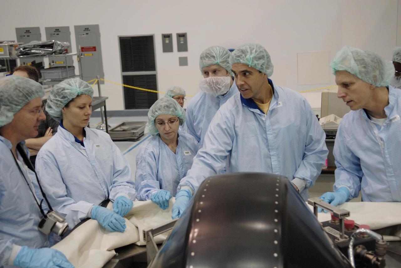 KENNEDY SPACE CENTER, FLA. -- In the Space Station Processing Facility, members of the STS-118 crew learn important information from technicians about the control moment gyro (CMG) in front of them that is part of the payload on their mission. Second from left is Mission Specialist Tracy Caldwell; at right are Mission Specialists Richard Mastracchio (pointing) and Clayton Anderson, who will be flying on STS-118 to join the Expedition 15 crew as flight engineer on the International Space Station. The CMG will replace a faulty one on the International Space Station. The payload also includes the SPACEHAB single cargo module, the third starboard truss segment (ITS S5) and the external stowage platform 3 (ESP3). STS-118 is targeted to launch June 28 from Launch Pad 39A. Photo credit: NASA/Kim Shiflett